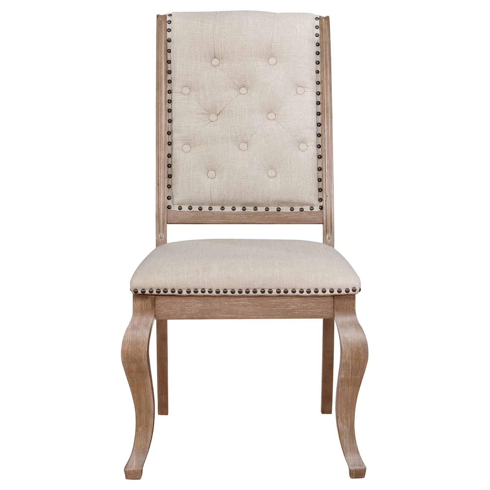 Tufted beige fabric dining chair with antique brass nailhead trim and carved wooden legs