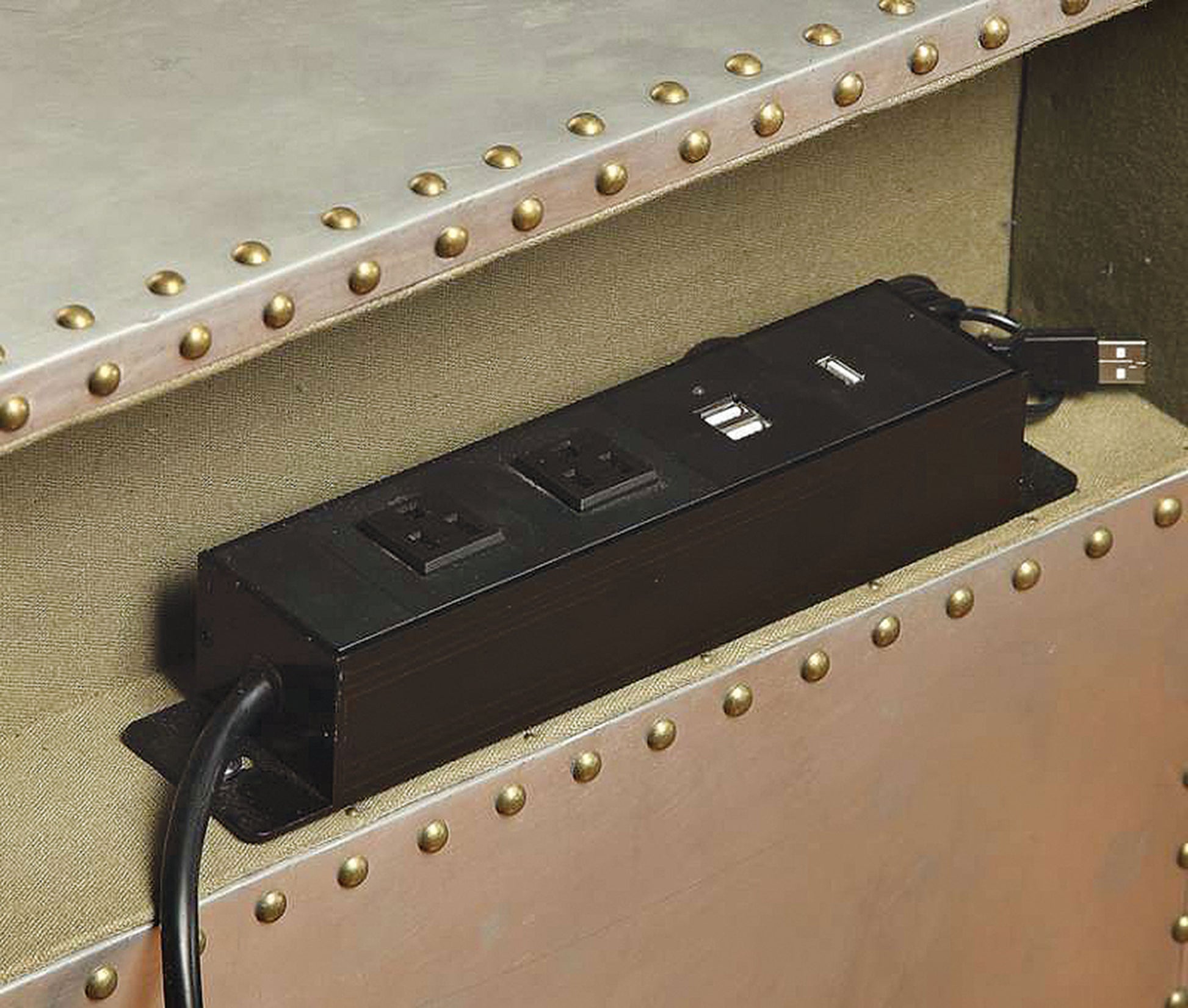 Black power strip with two AC outlets and two USB ports mounted on metallic surface