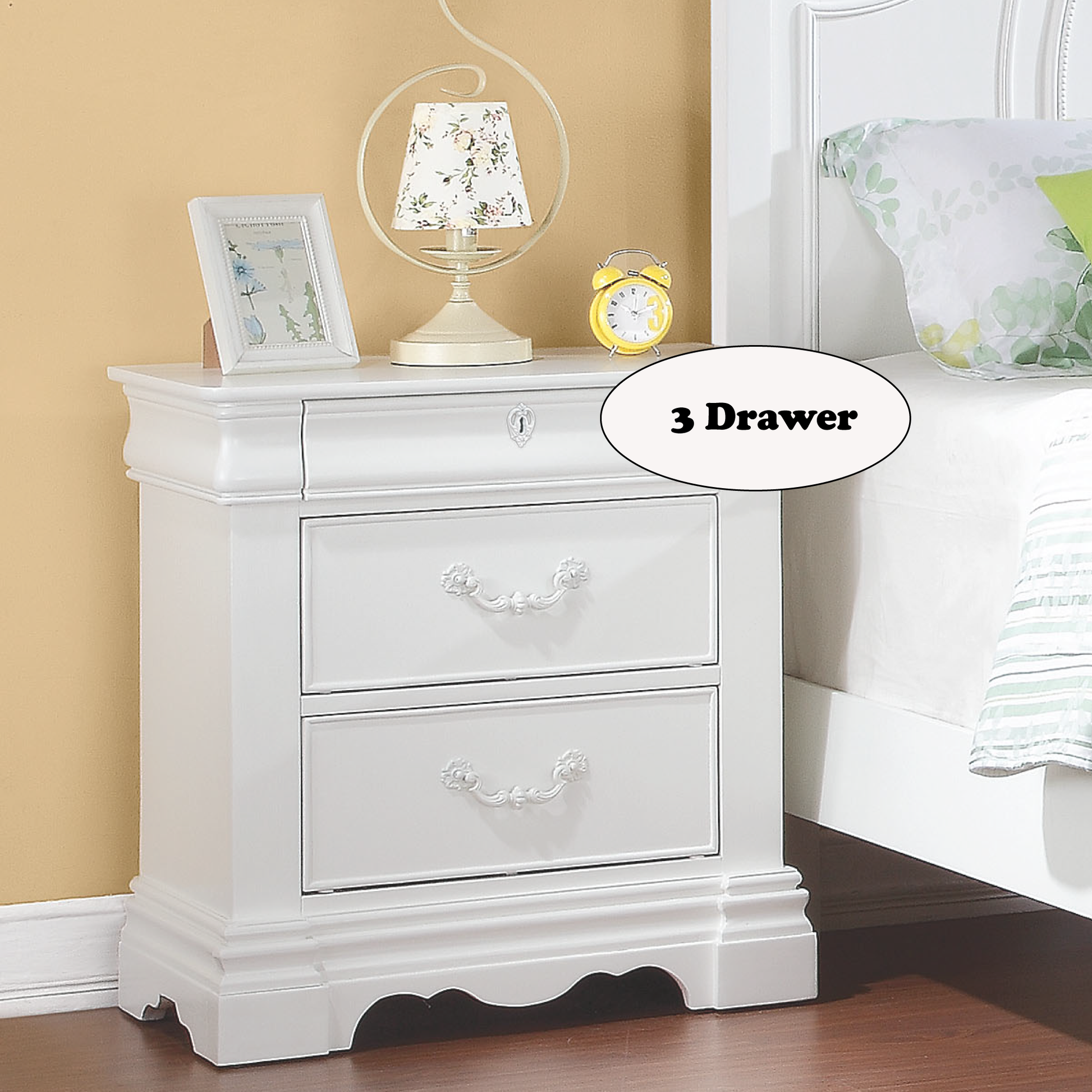 White drawer nightstand with ornate drawer pulls and detailed base