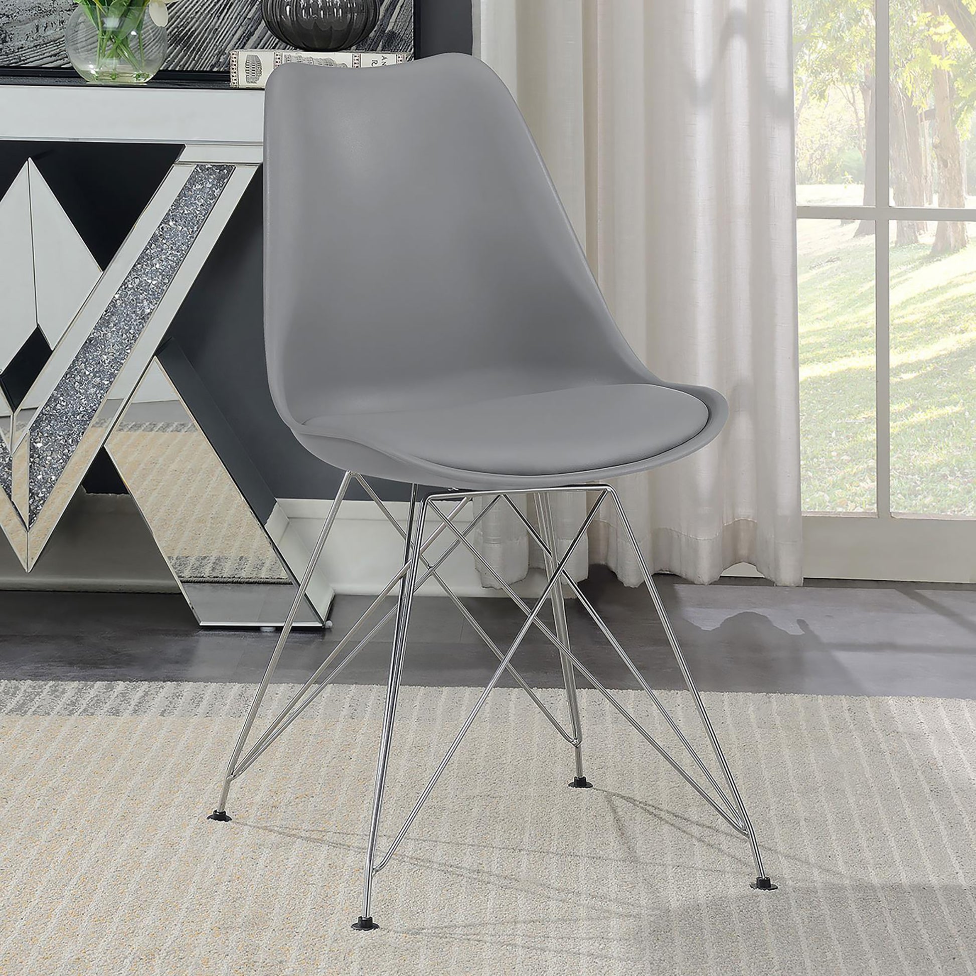 Modern grey plastic dining chair with chrome wire legs on a beige rug