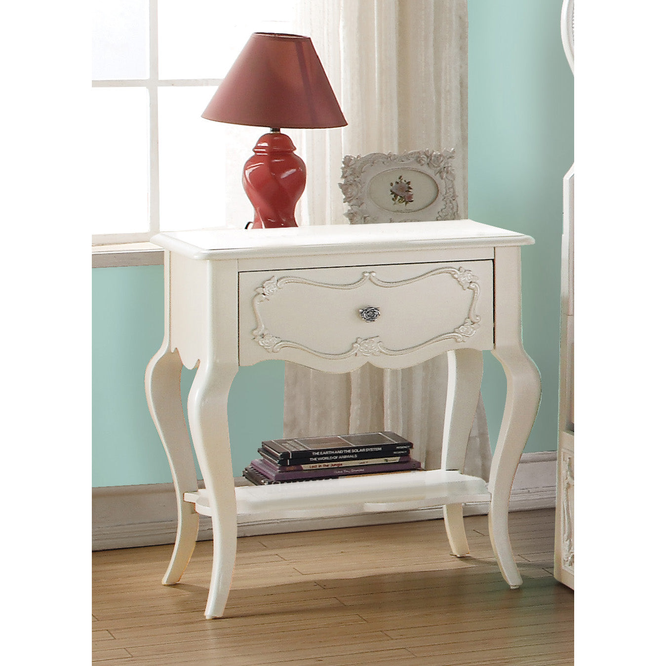 Cream ornate nightstand with single drawer and lower shelf holding books