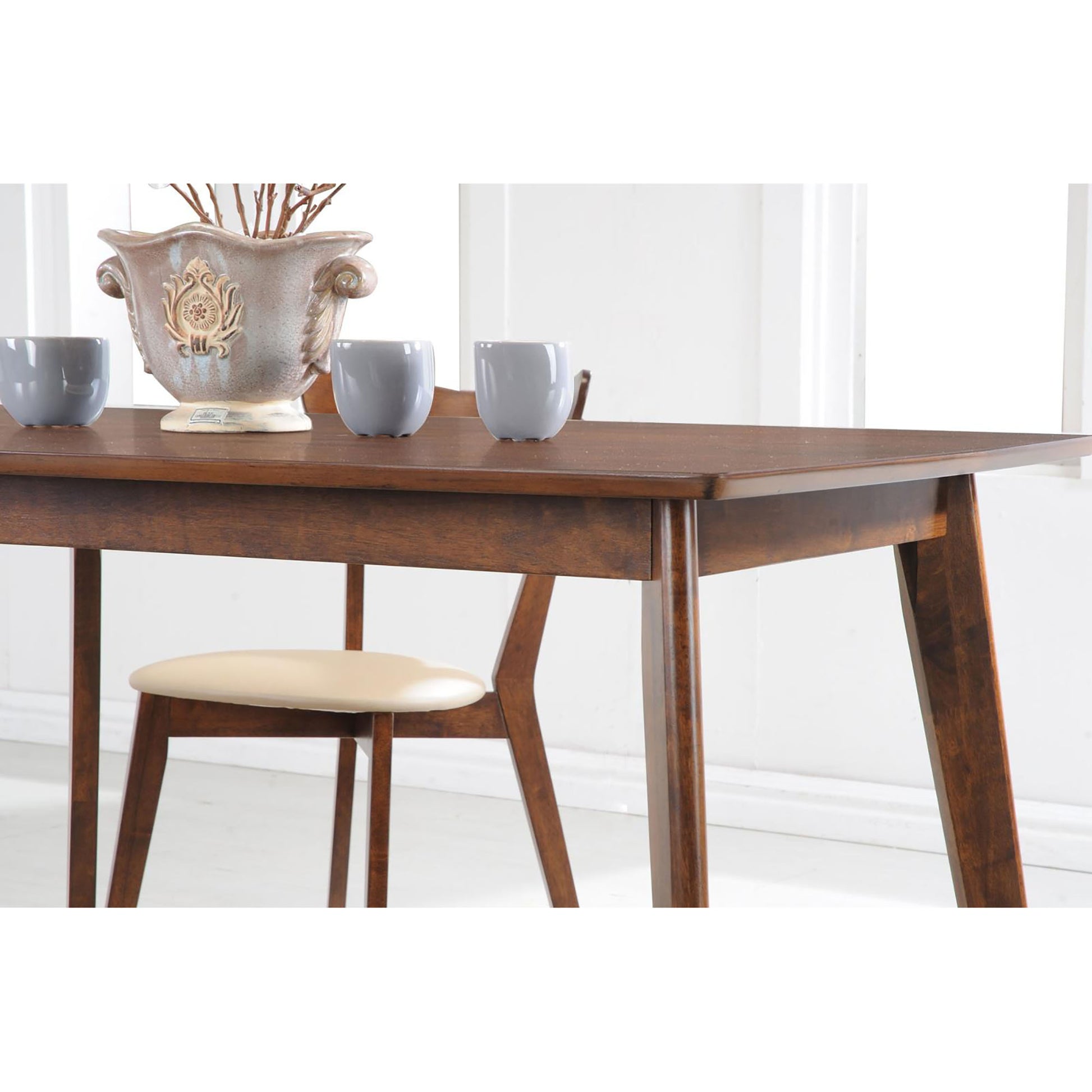 Warm walnut dining table with tapered legs and a single light beige chair