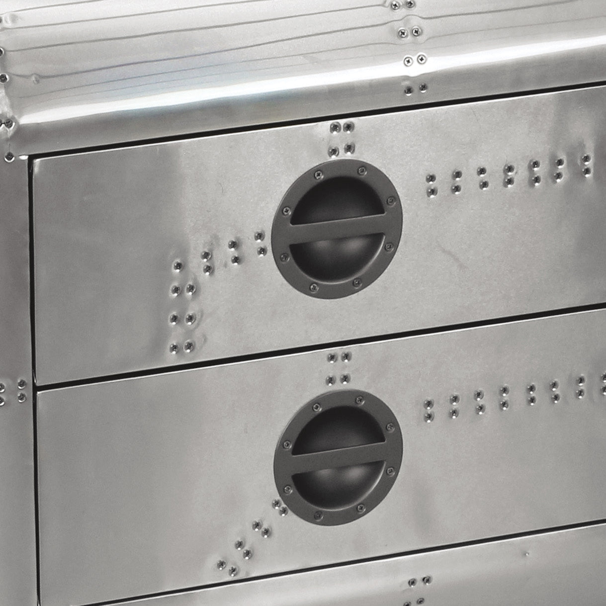 Closeup of two silver metal dresser drawers with round dark gray handles and visible rivets
