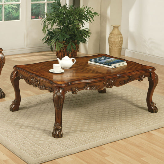 Ornate carved wood coffee table with a marquetry inlay tabletop a teapot and cup