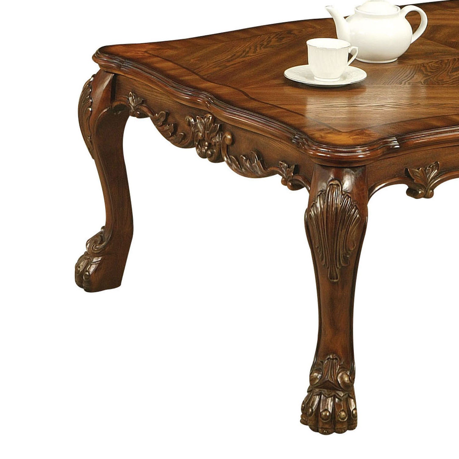 Ornate dark wood carved coffee table with claw feet and a white teacup set