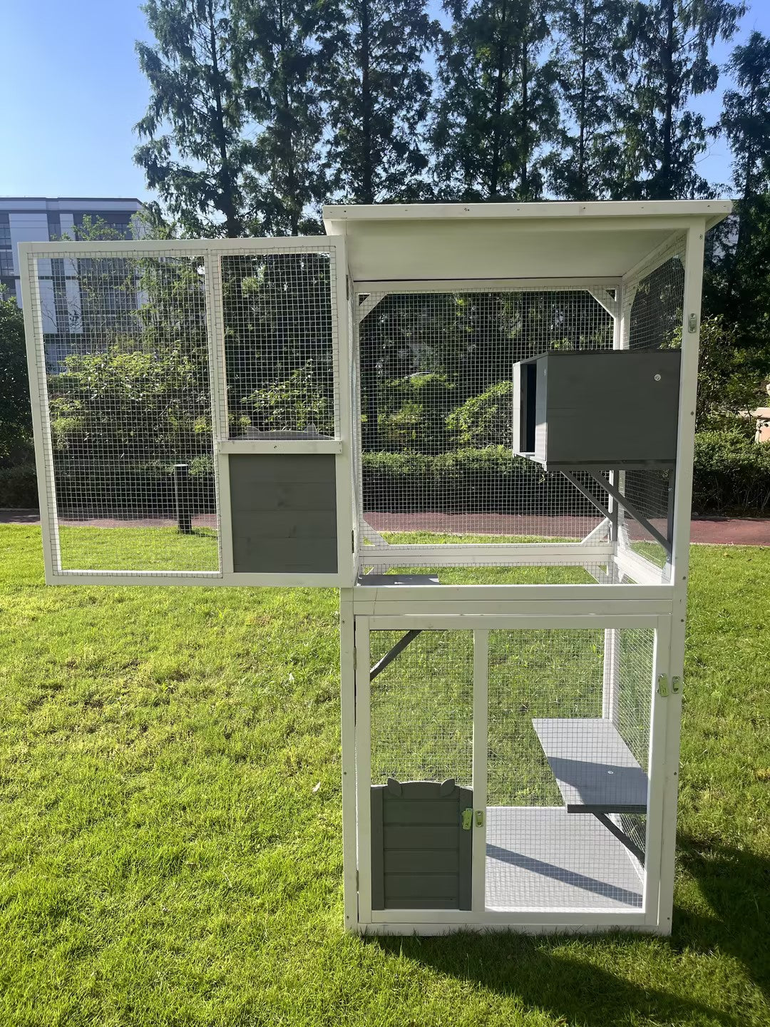White and grey multilevel outdoor cat enclosure with mesh sides and a nesting box
