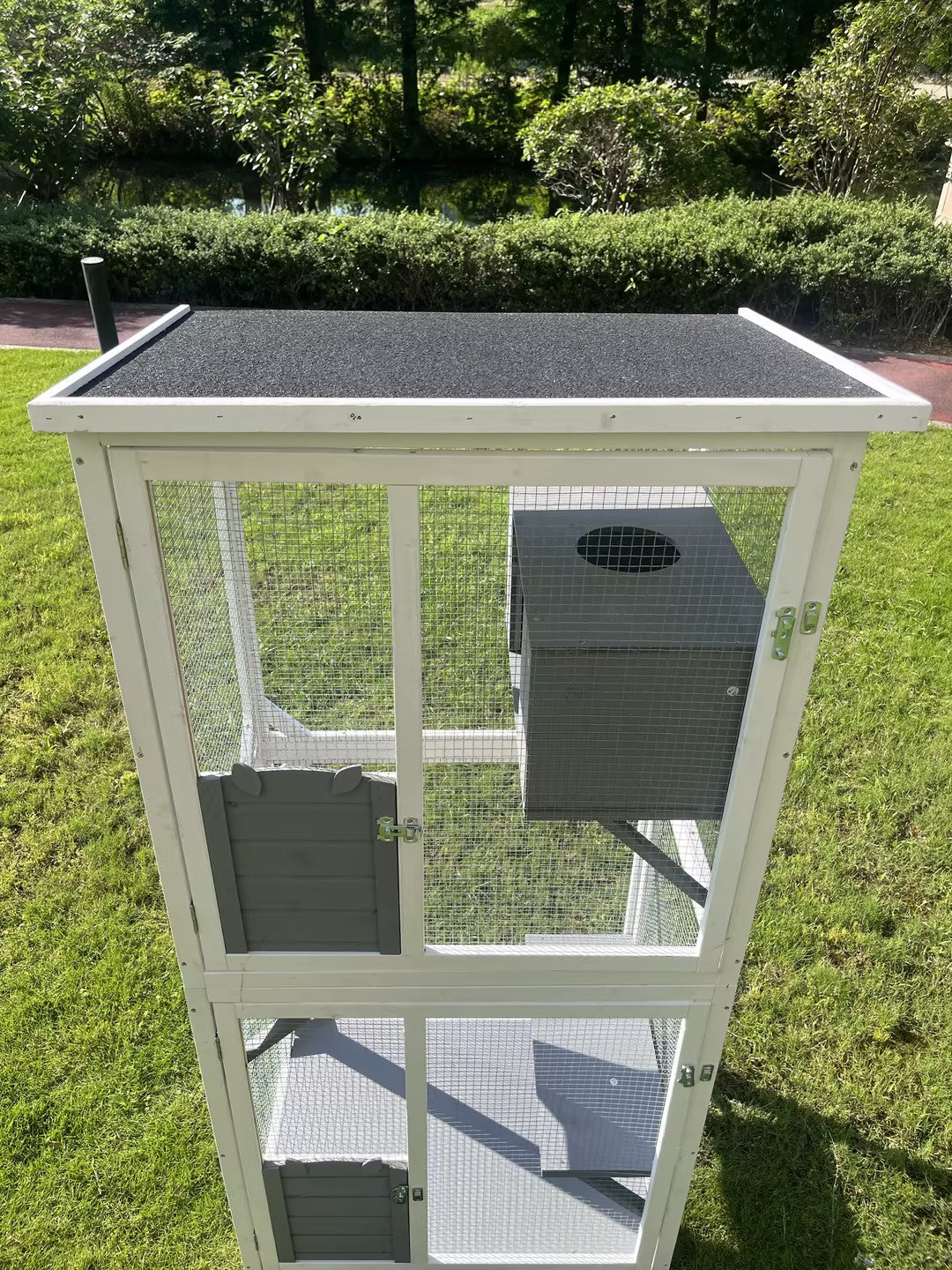 White wooden outdoor rabbit hutch with two levels and a grey nesting box