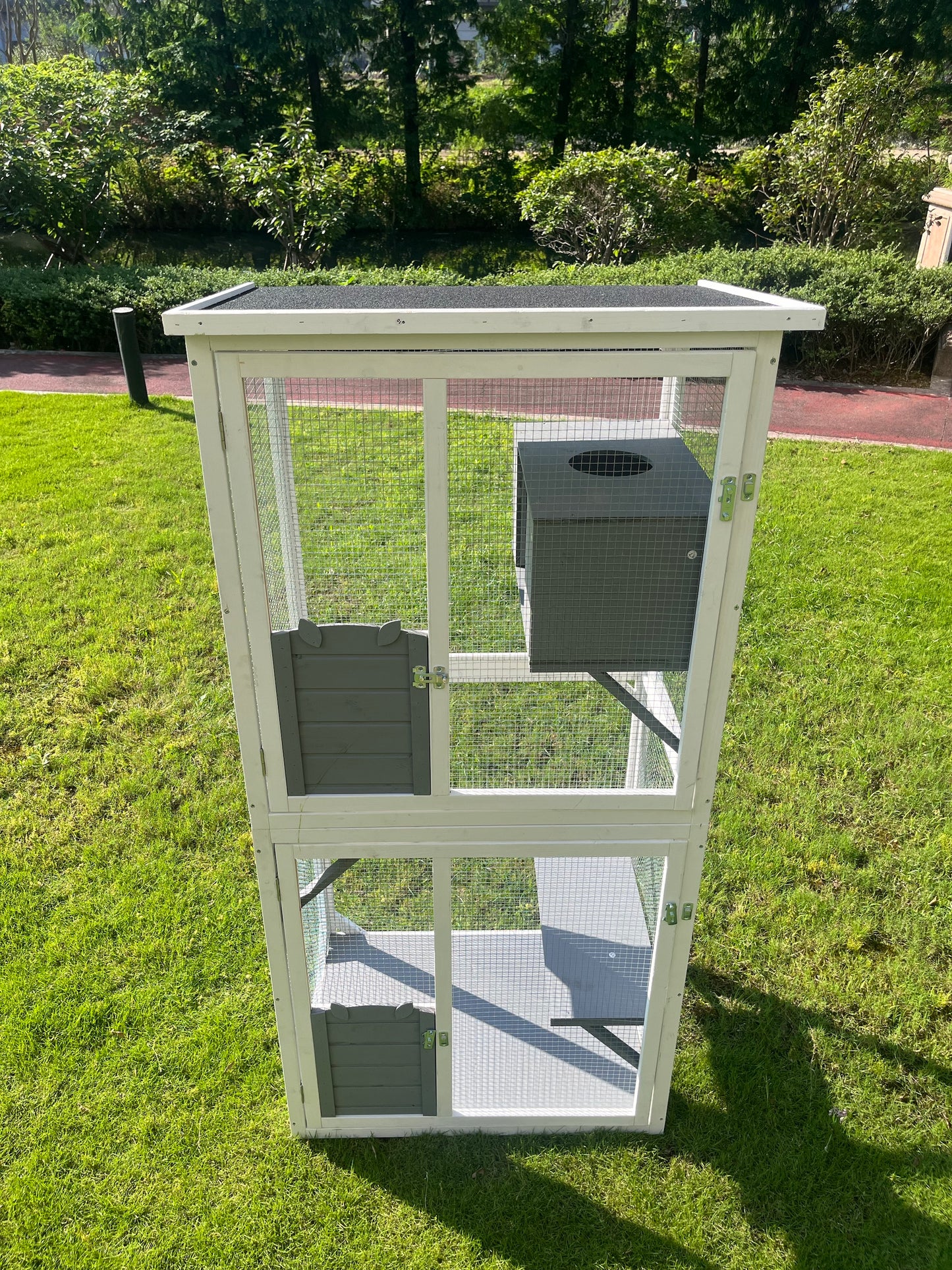 Tall white wooden rabbit hutch with multiple levels and a dark grey nesting box