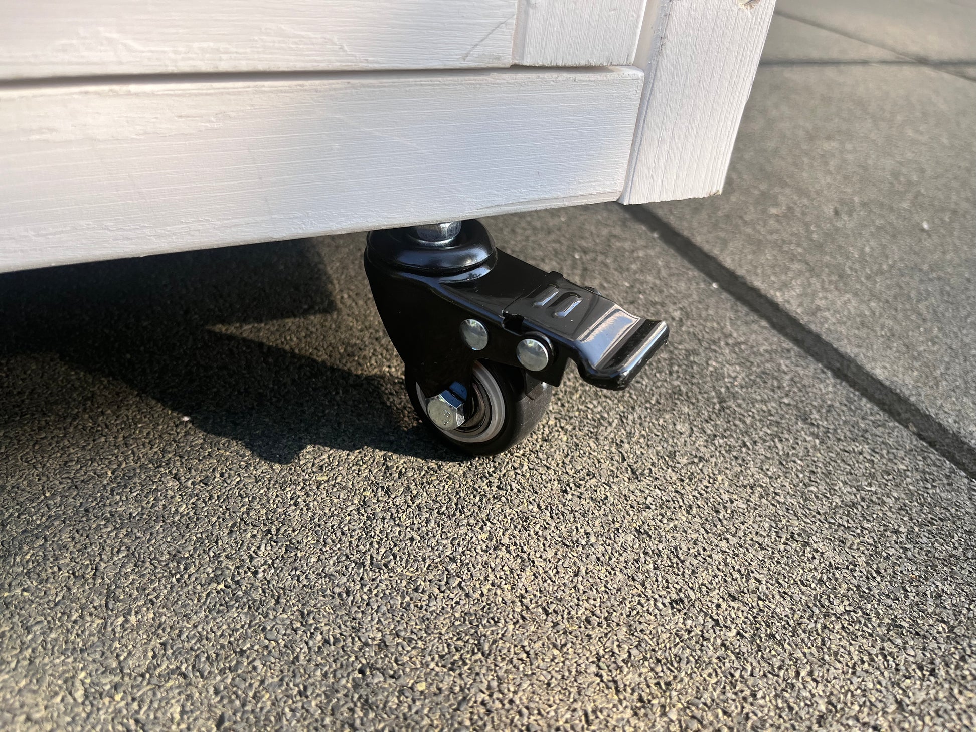 Black swivel caster wheel with brake for furniture mobility and secure placement