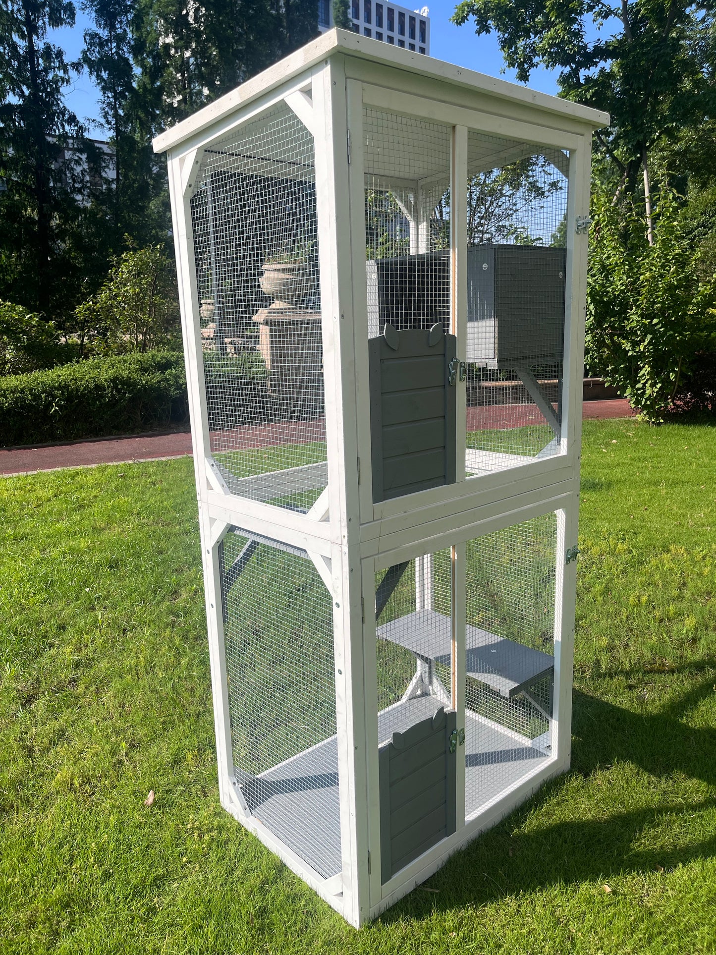 White wooden outdoor catio with multiple levels and grey doors
