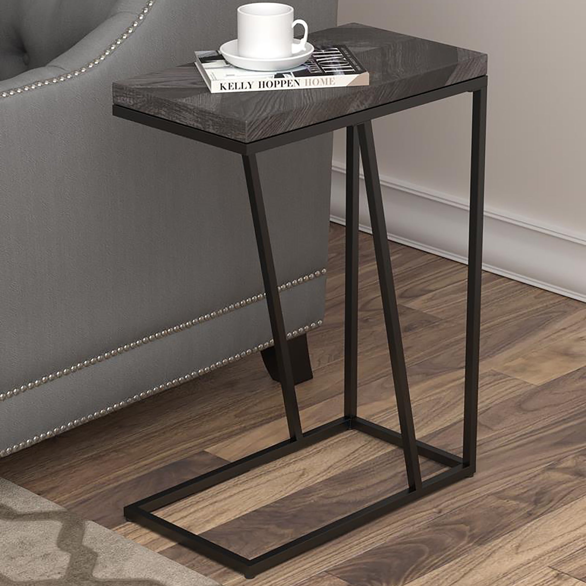 Modern Ctable with dark wood finish top and black metal frame holding a book and mug
