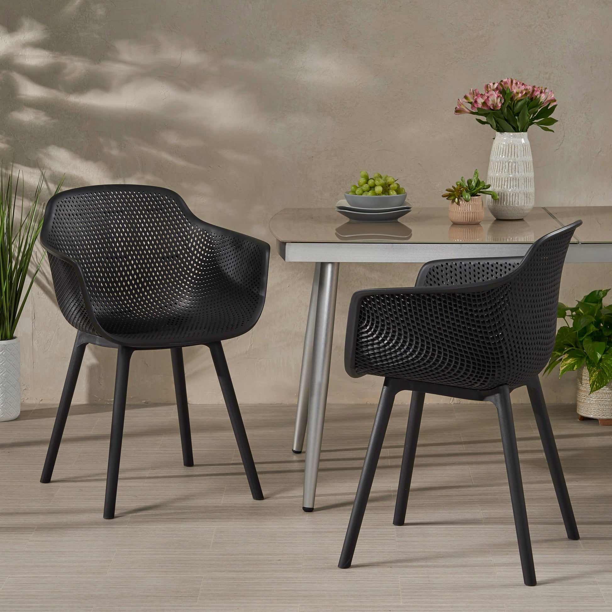 Modern black molded plastic patio chair with diamond pattern cutouts