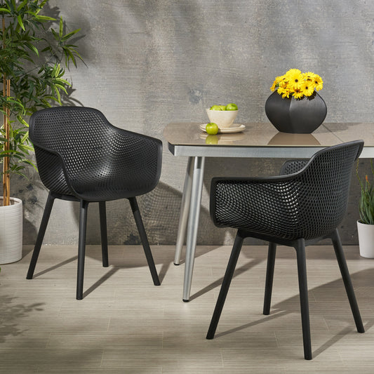 Two black outdoor dining chairs with a unique perforated design perfect for patio seating
