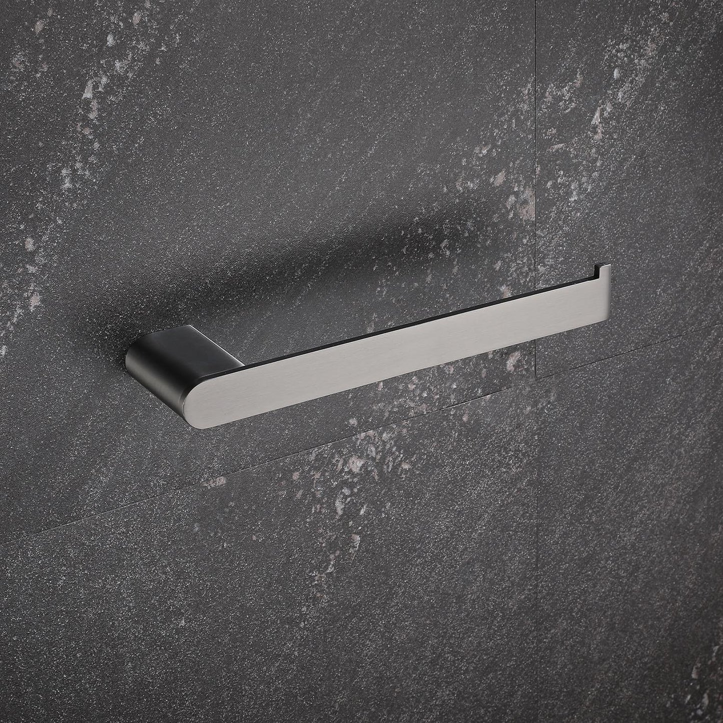 Sleek stainless steel toilet paper holder with a brushed finish on a dark textured wall