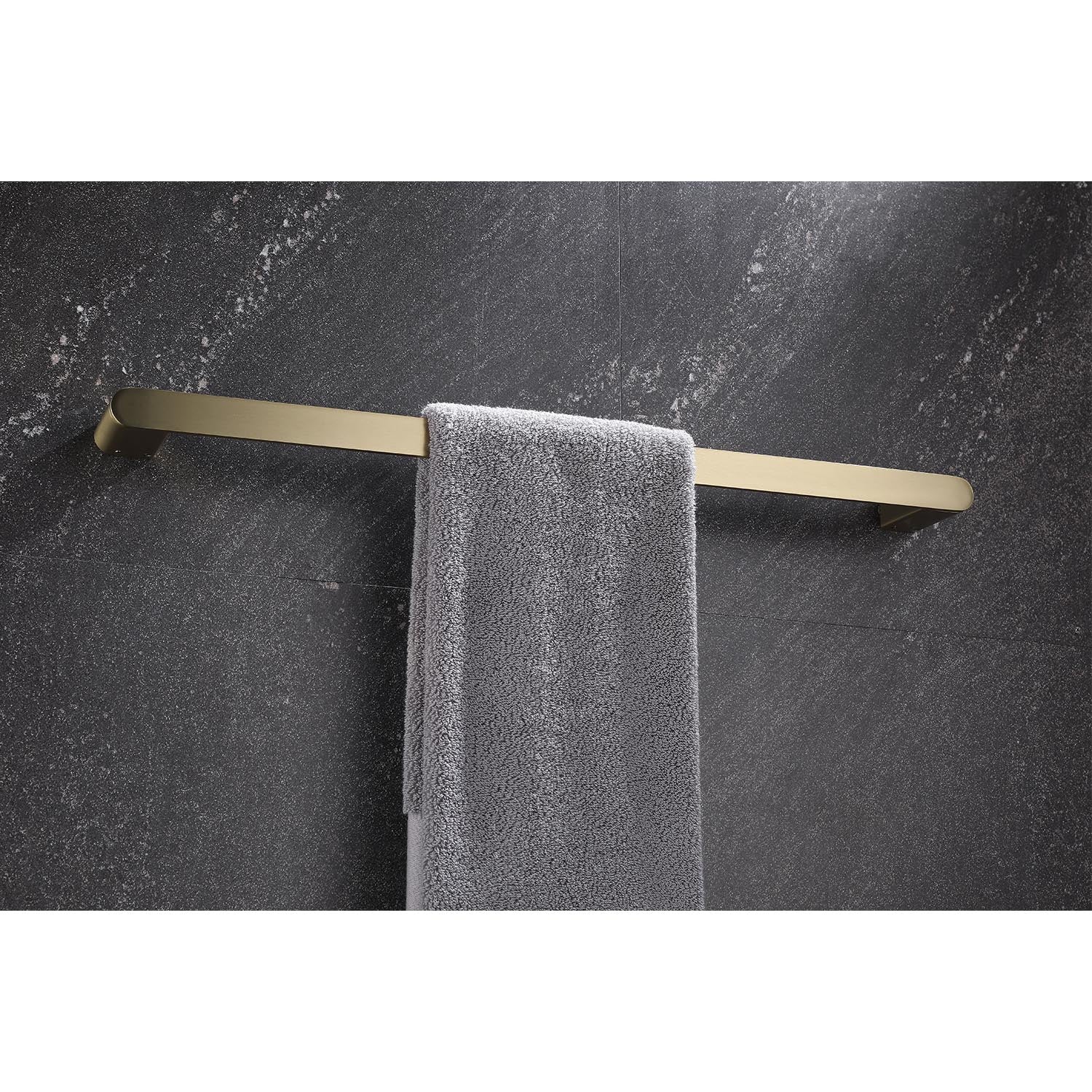 Modern brushed brass towel bar holding a grey bath towel