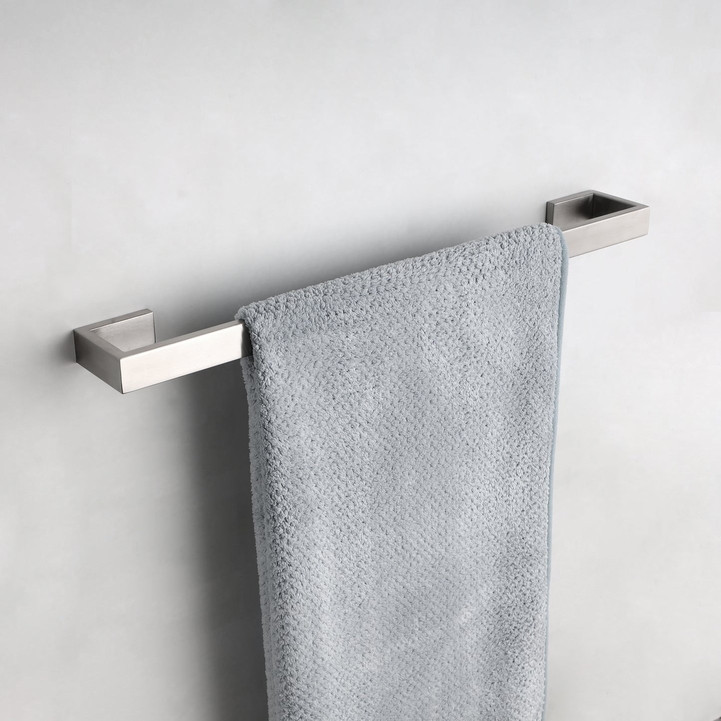 Modern brushed nickel towel bar with a single grey bath towel