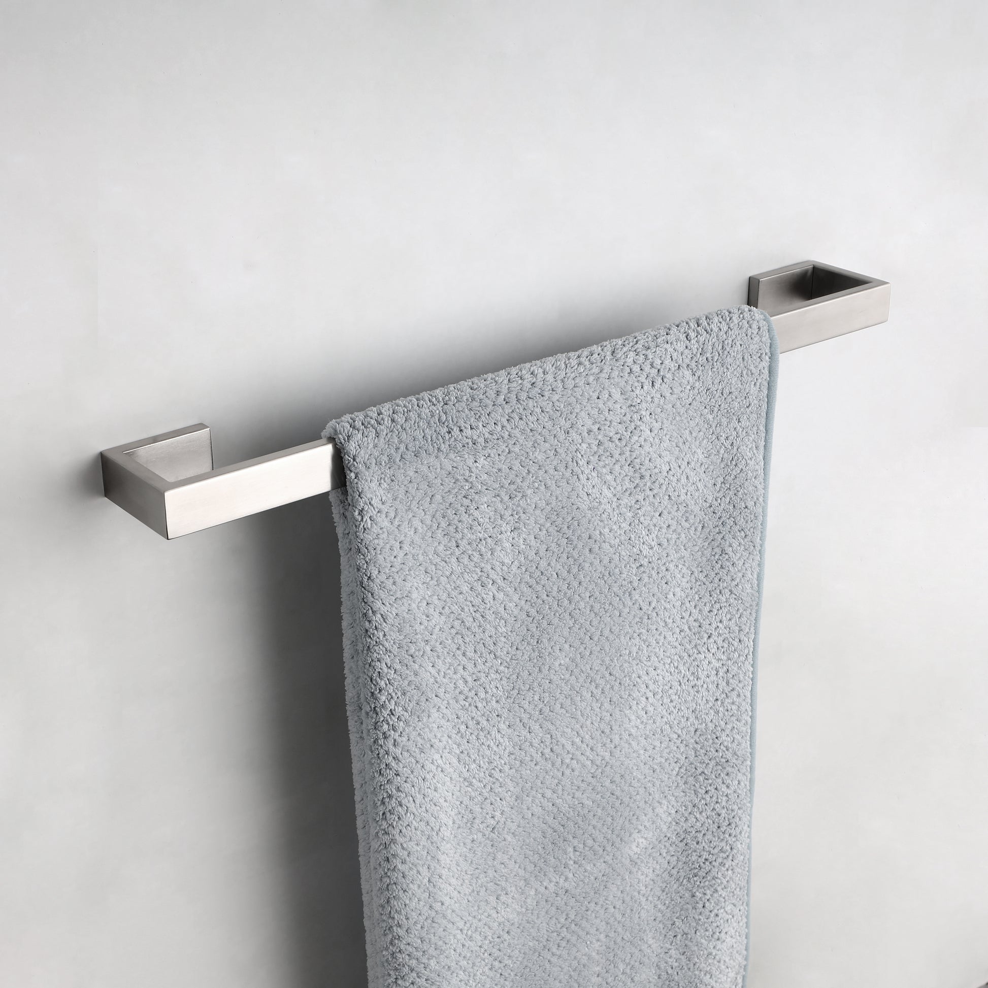 Modern brushed nickel towel bar with a single grey bath towel