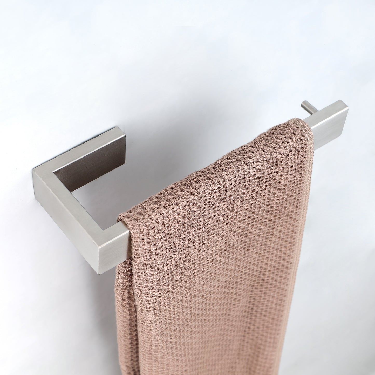 Brushed nickel modern towel bar holding a textured beige towel