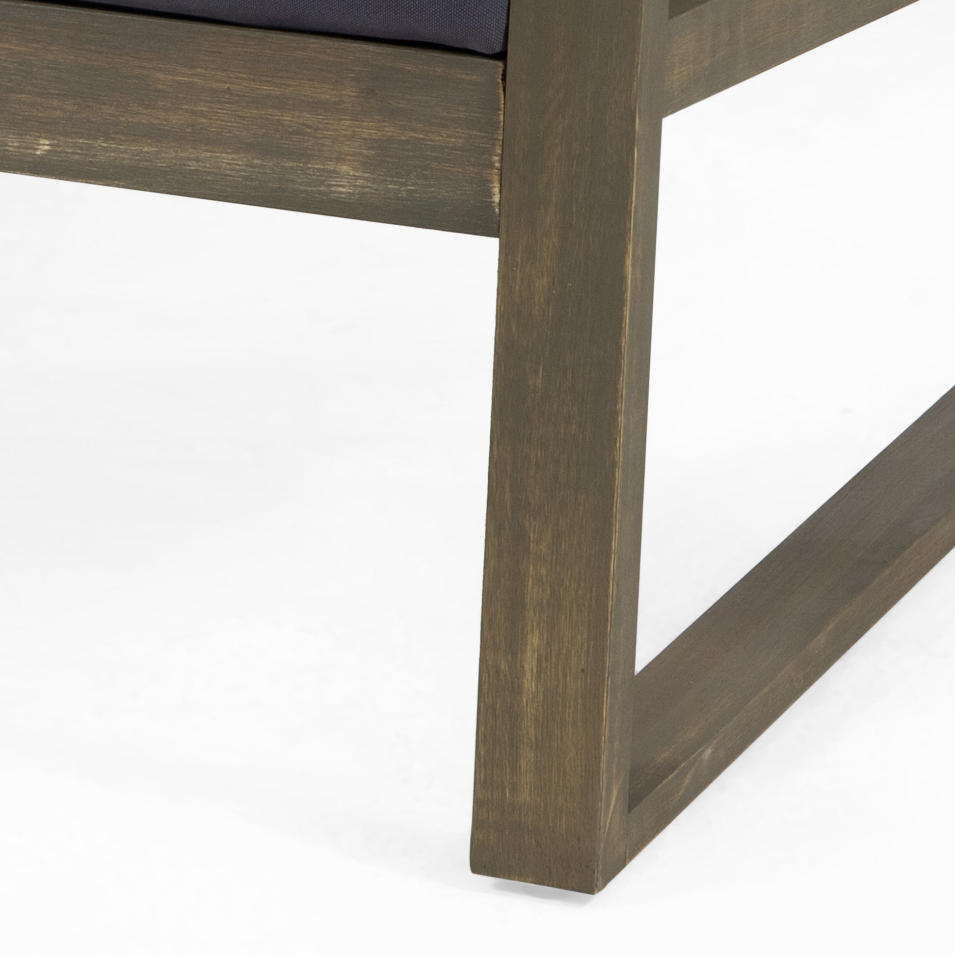 Dark wood outdoor chair frame with a weathered finish and navy cushion visible