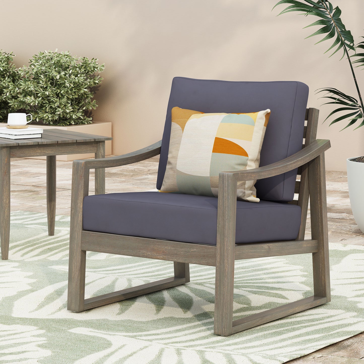 Dark grey outdoor chair with modern wooden frame and geometric throw pillow