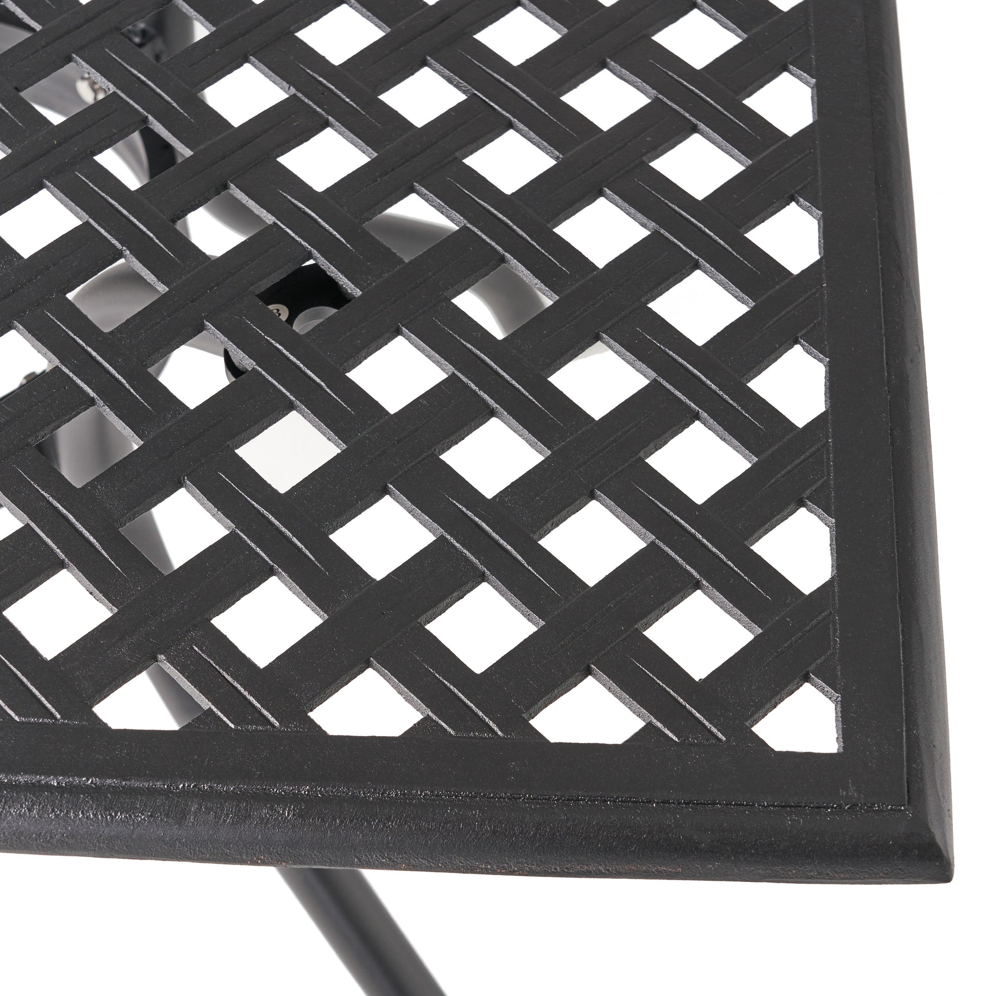 Closeup of a black cast iron patio table top with a woven diamond pattern