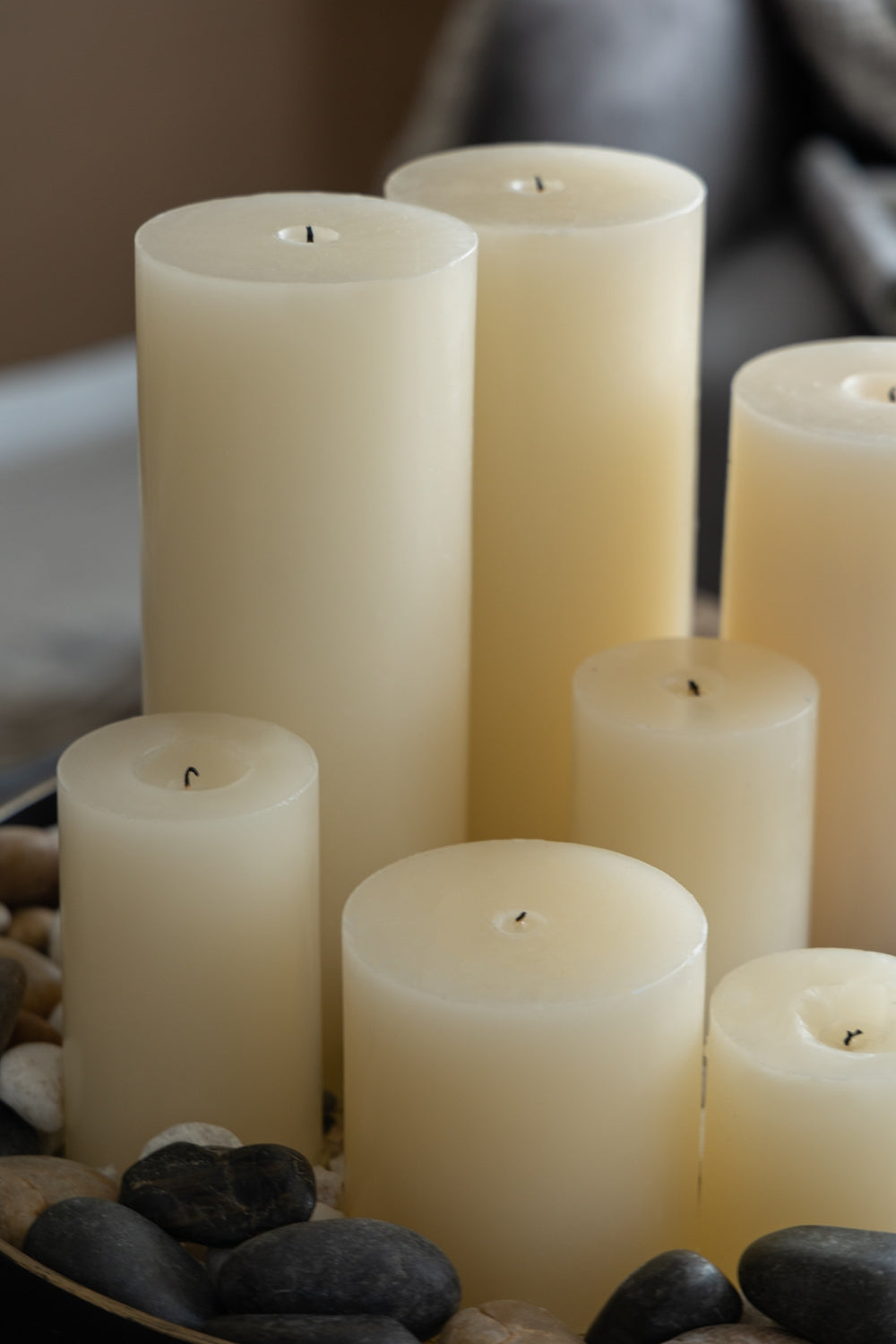 Set of seven ivory pillar candles on decorative stones creating a serene ambiance