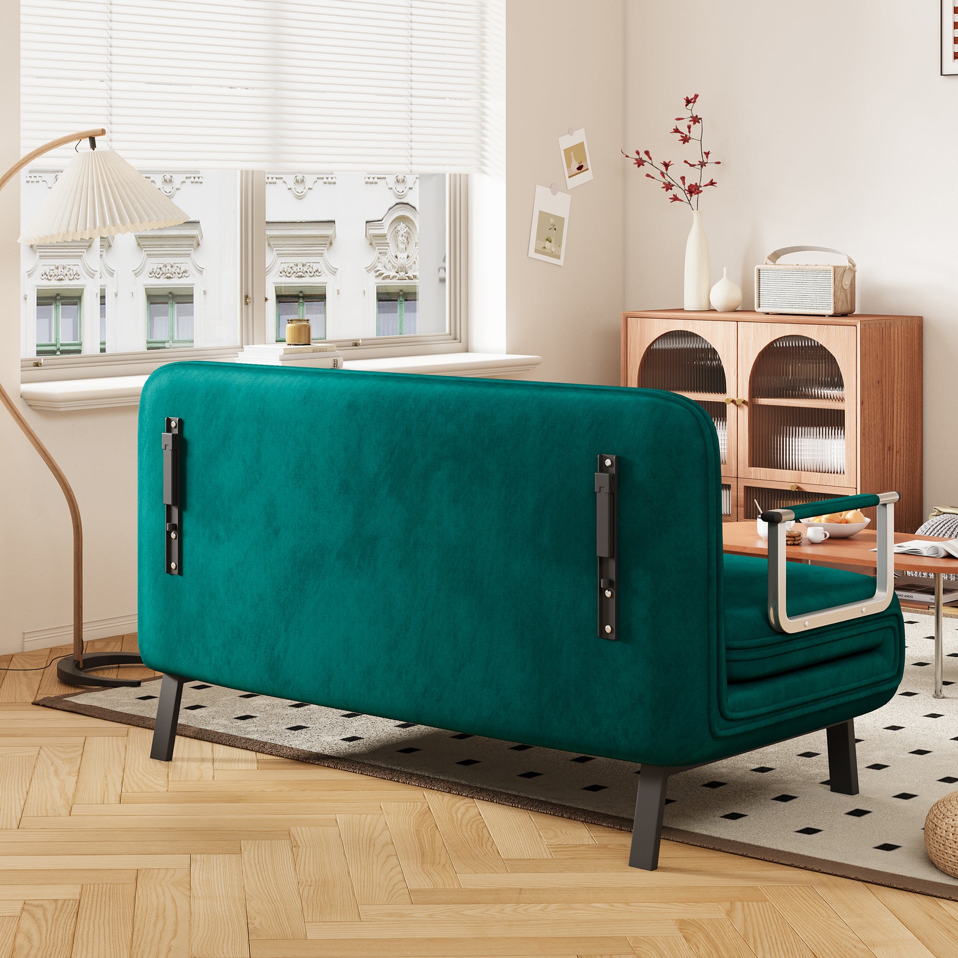 Deep green velvet sofa bed with modern metal legs and plush cushions