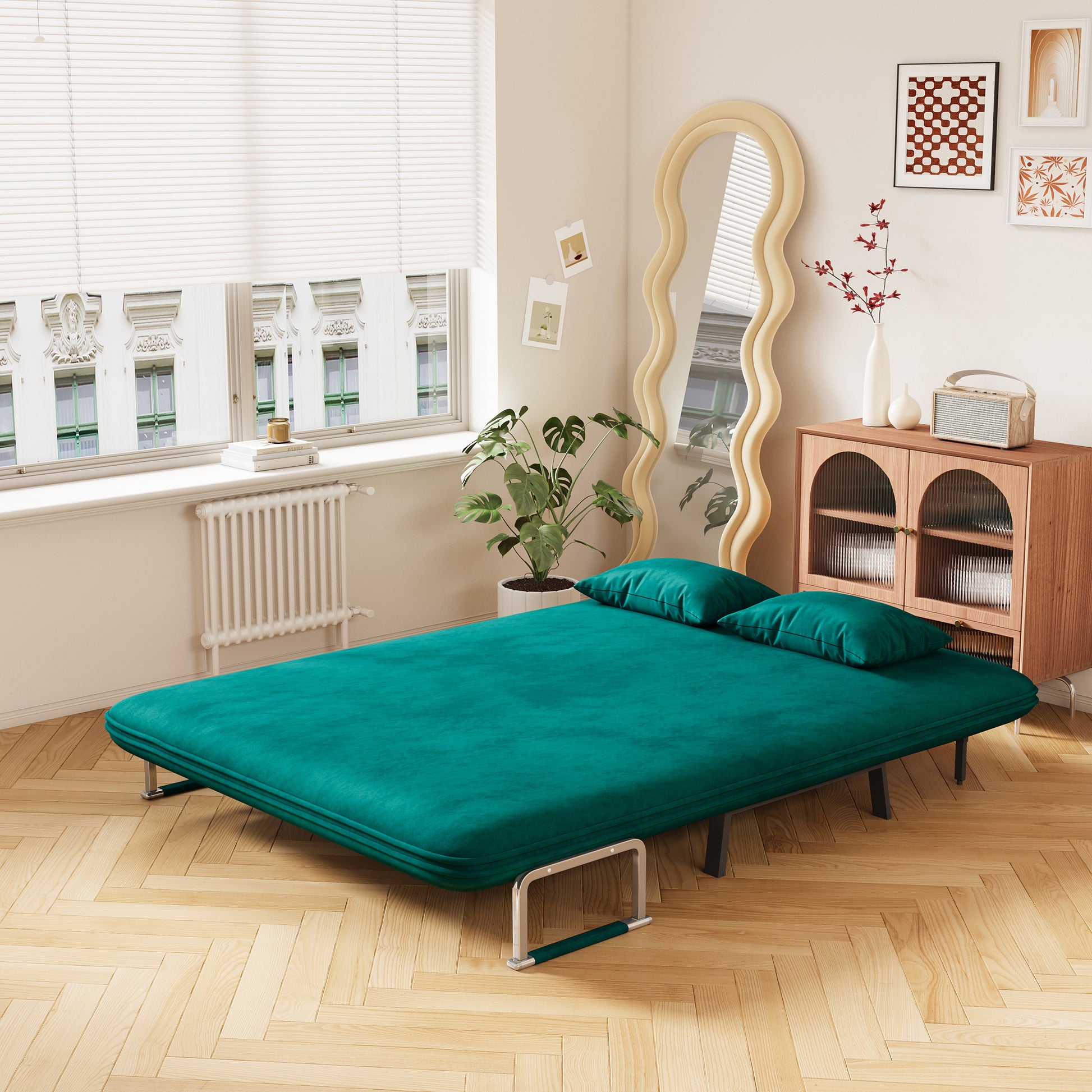 Teal velvet sofa bed with metal frame and two pillows for guest room