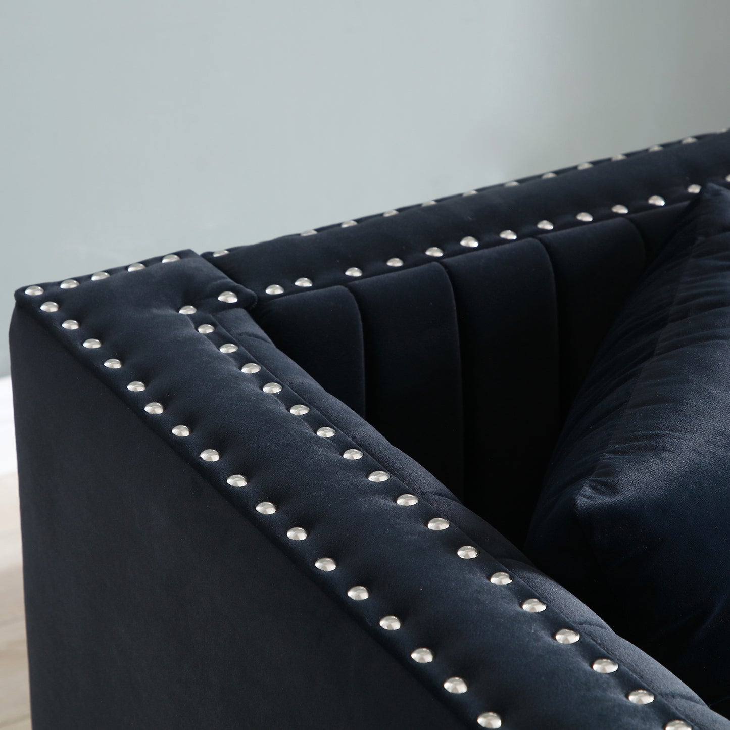 Deep blue velvet sofa with silver stud detailing and channel tufting modern accent piece