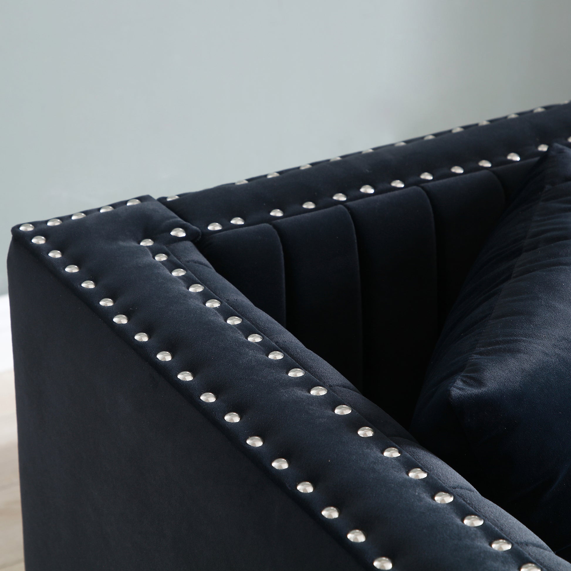 Deep blue velvet sofa with silver stud detailing and channel tufting modern accent piece