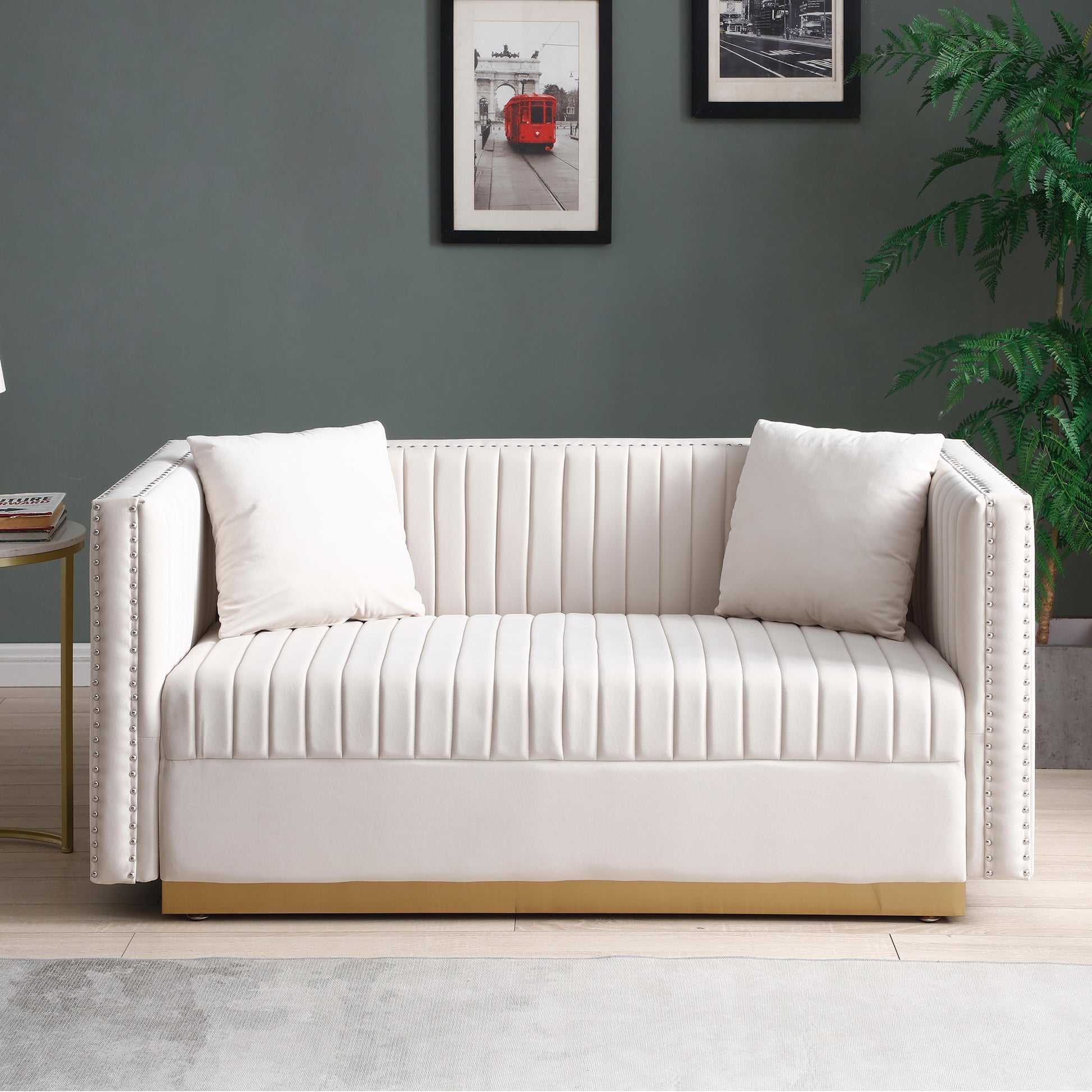 Cream velvet tufted sofa with gold base and silver nailhead trim