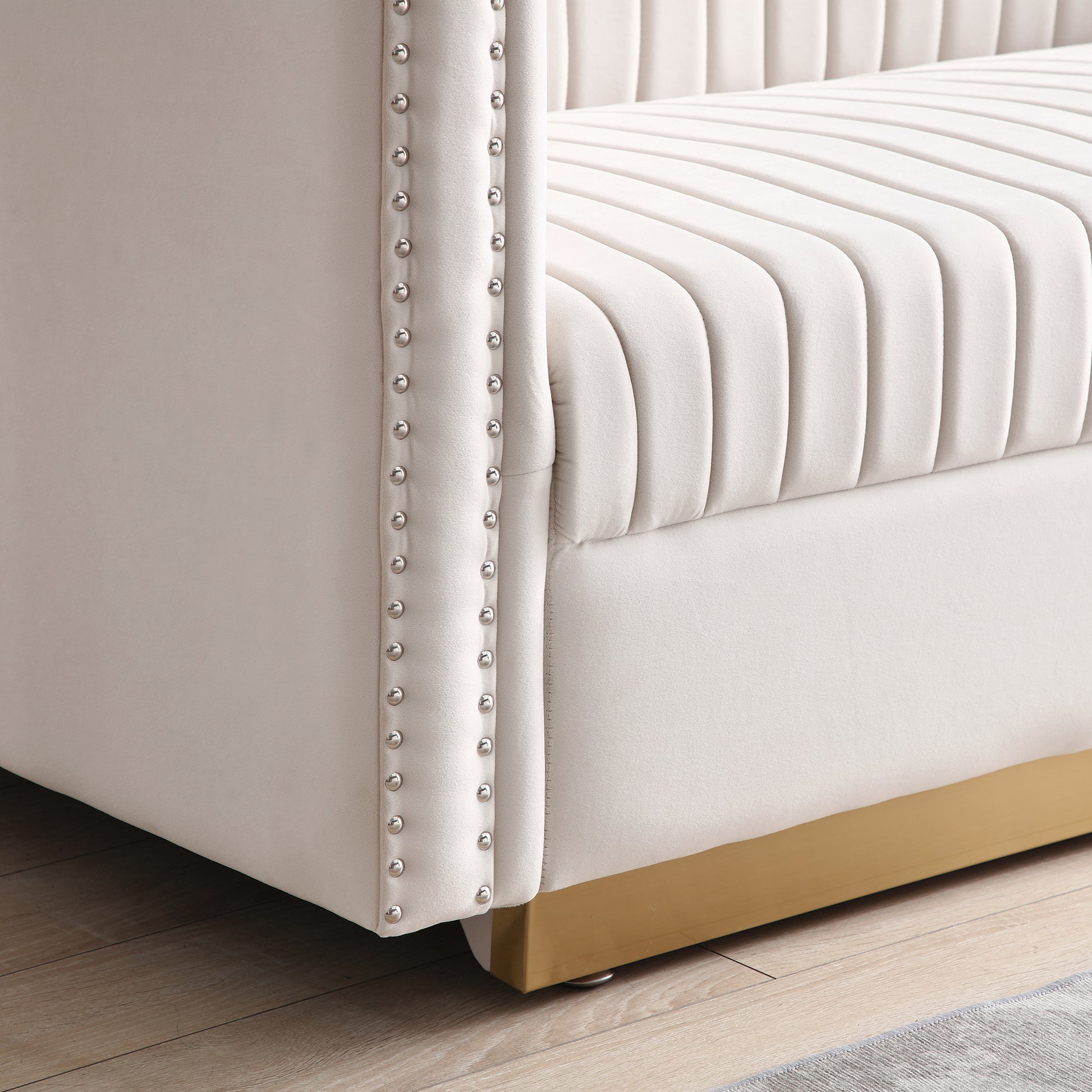 Cream velvet channeltufted sofa with silver nailhead trim and gold base