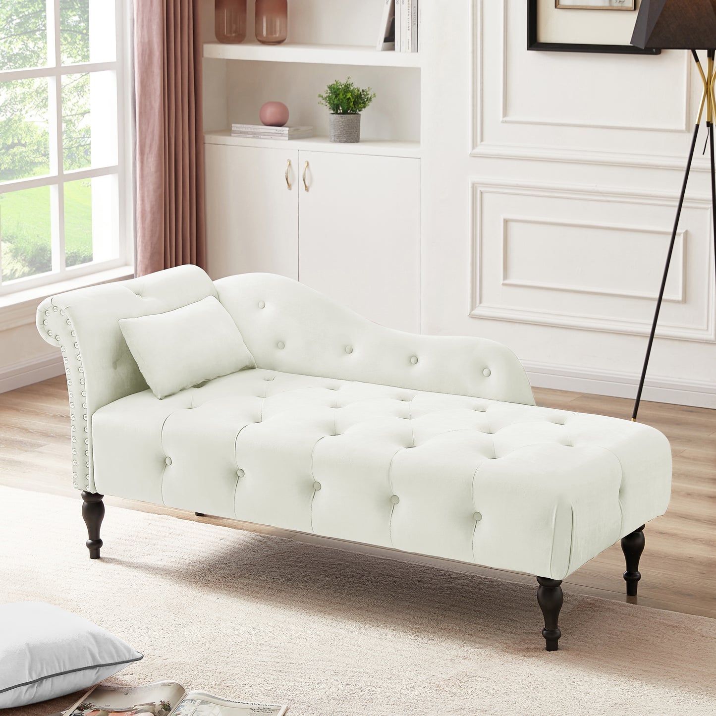 White velvet chaise lounge with button tufting and silver nailhead trim featuring dark wooden legs