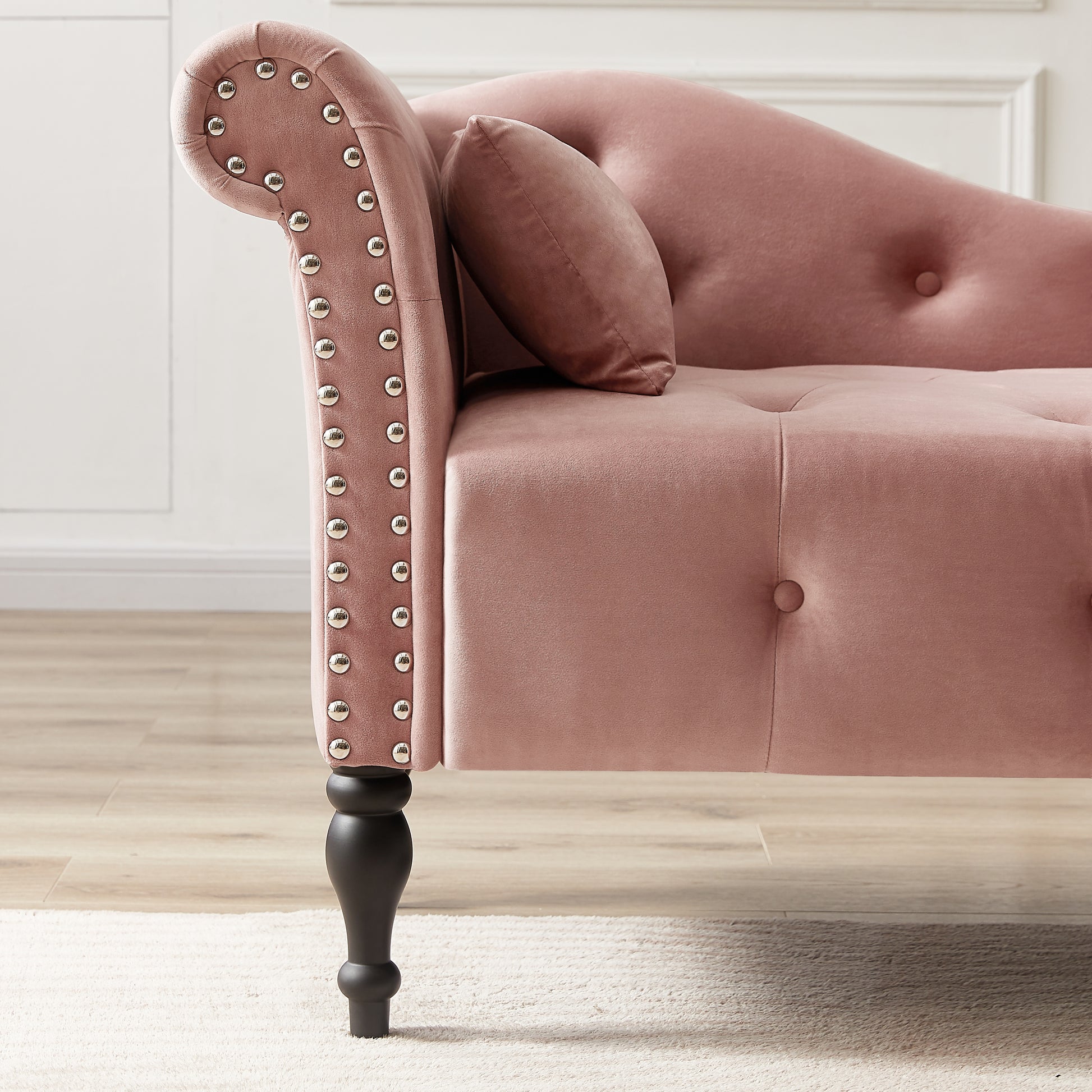 Plush pink velvet chaise lounge with silver nailhead trim and tufted details