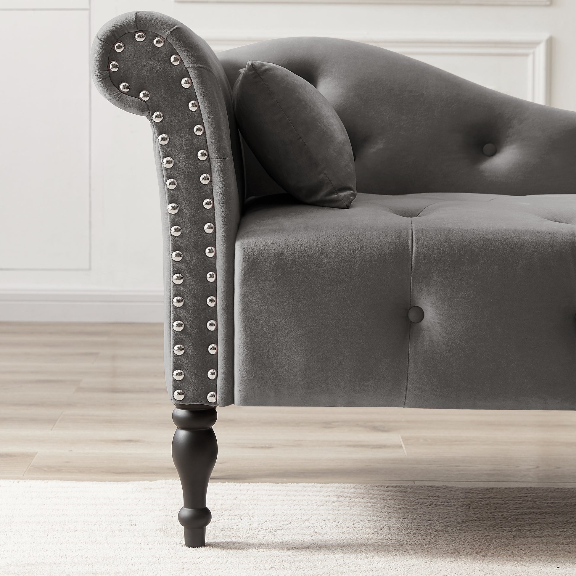 Grey velvet chaise lounge with silver nailhead trim and tufted back