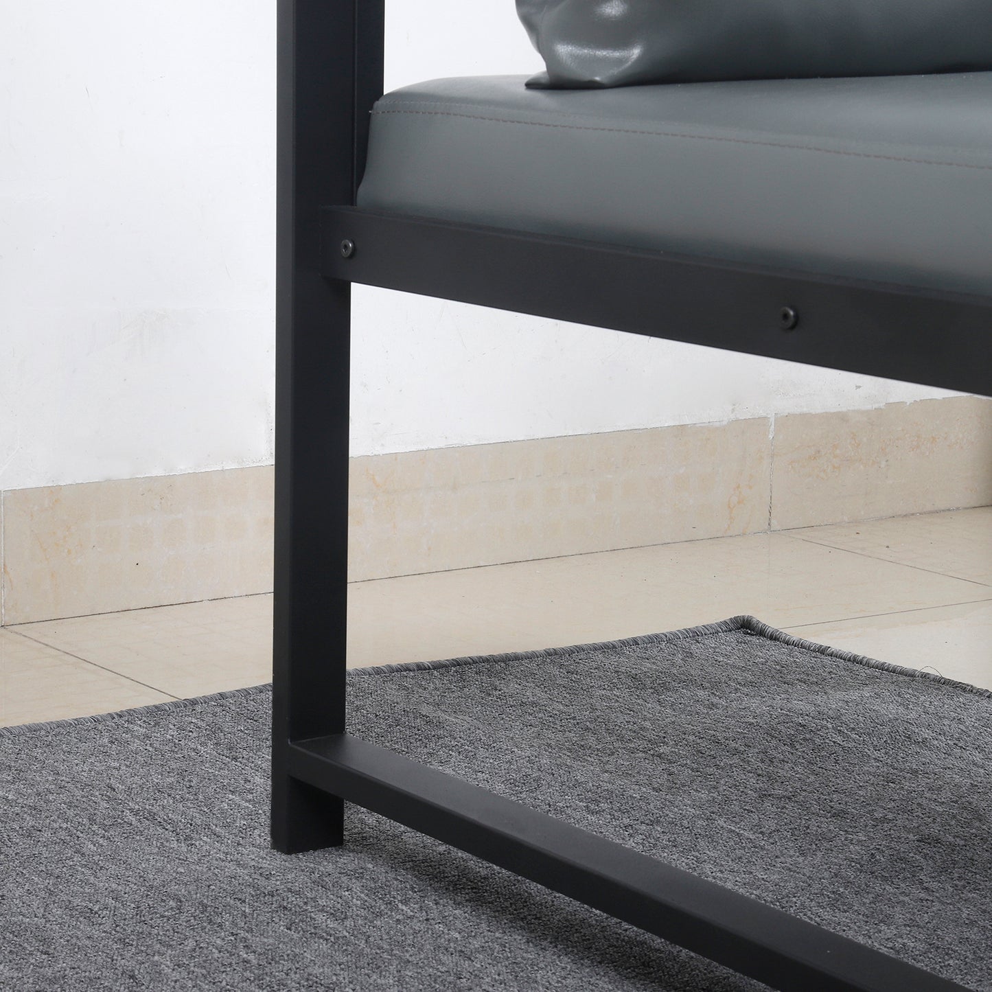 Closeup of a modern grey upholstered bench with a black metal frame