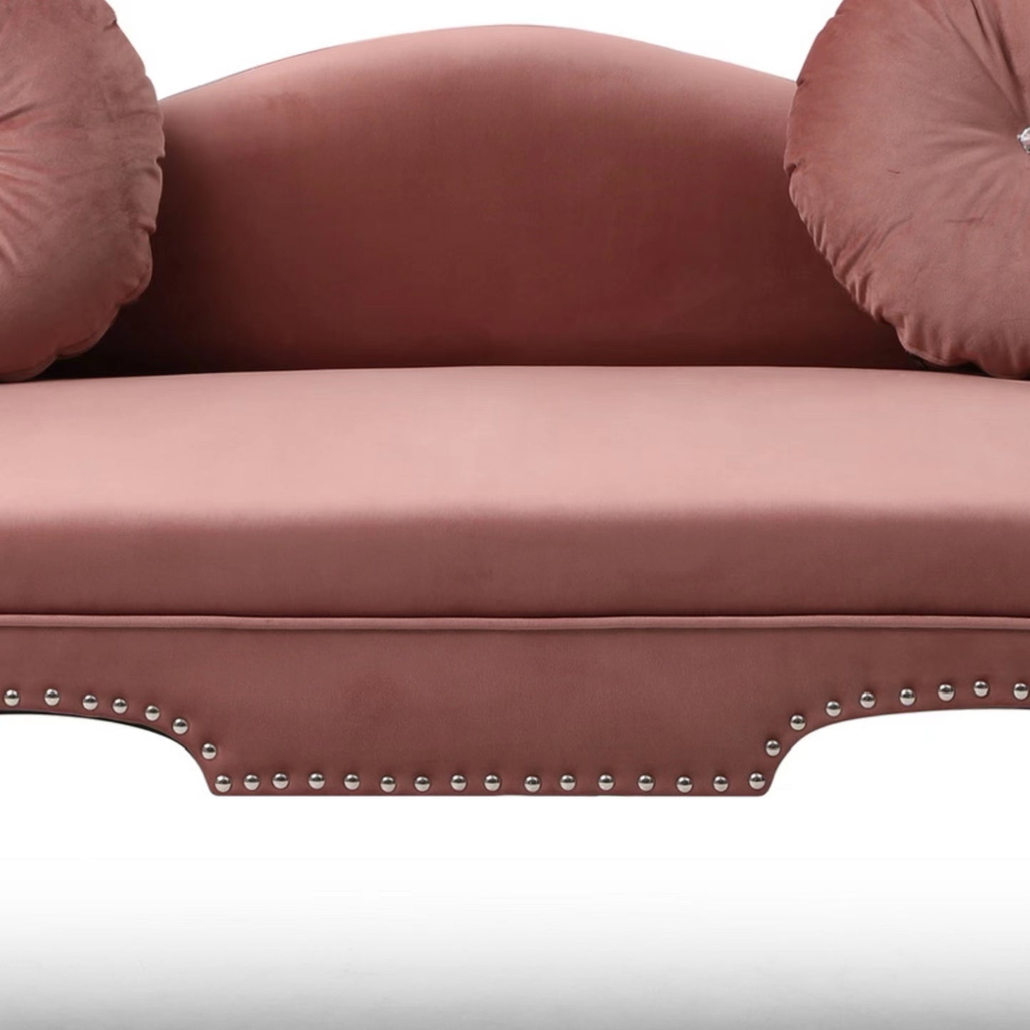 Dusty rose velvet sofa with ornate studded trim and round accent pillows