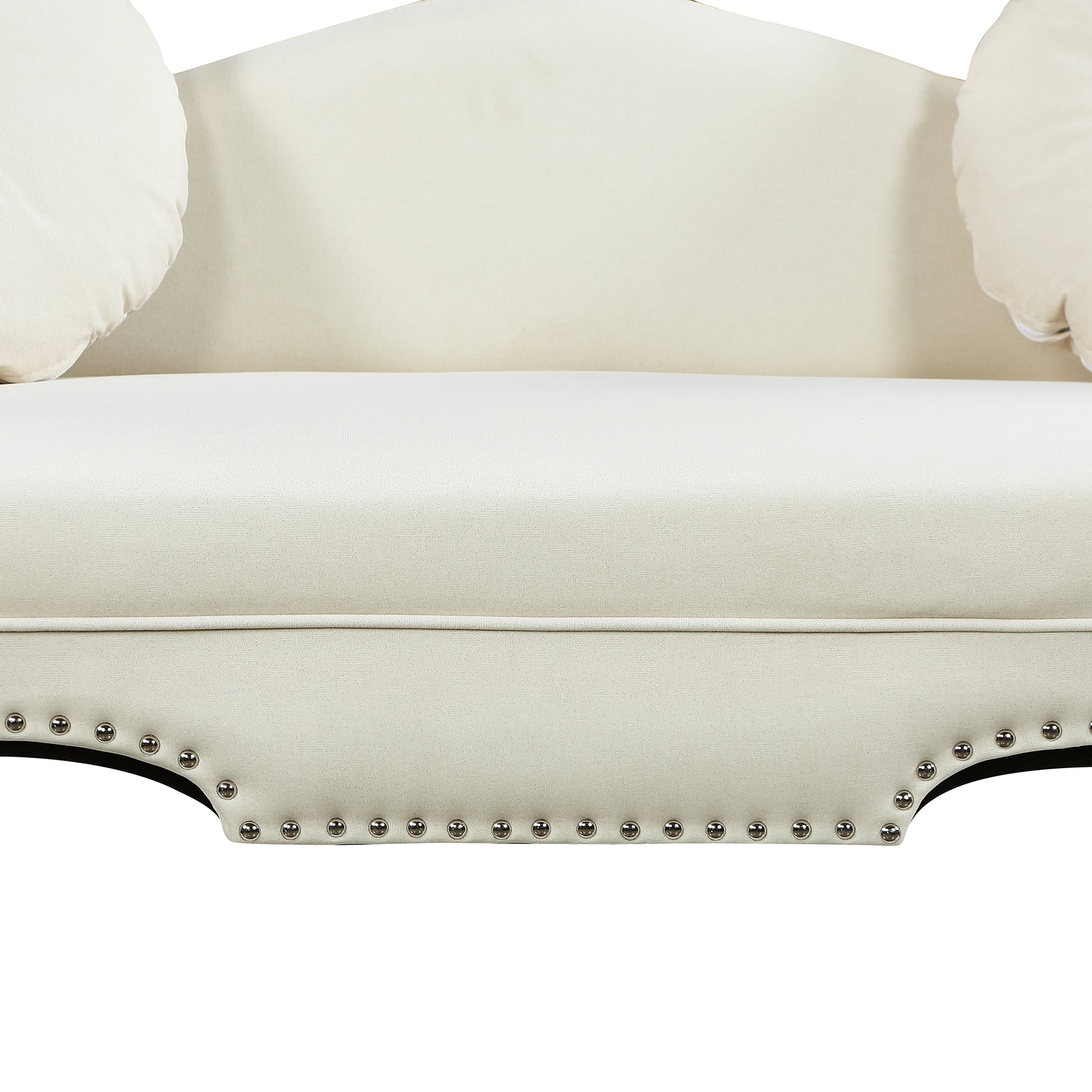 Cream tufted loveseat with decorative silver nailhead trim and round throw pillows