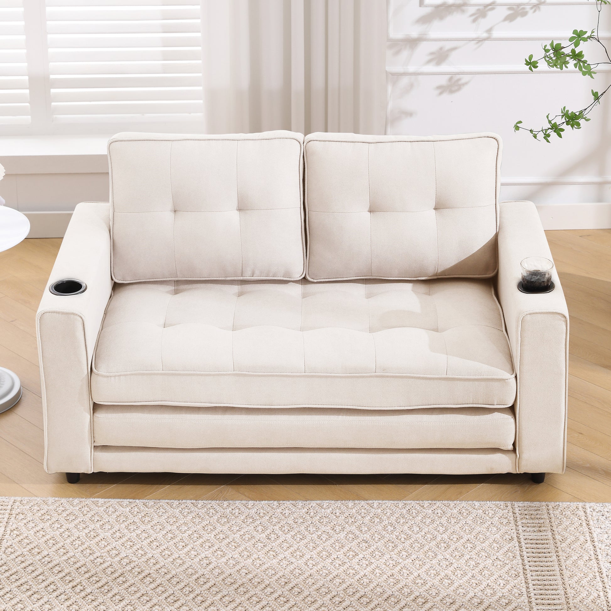 Cream upholstered loveseat with tufted cushions and builtin cup holders