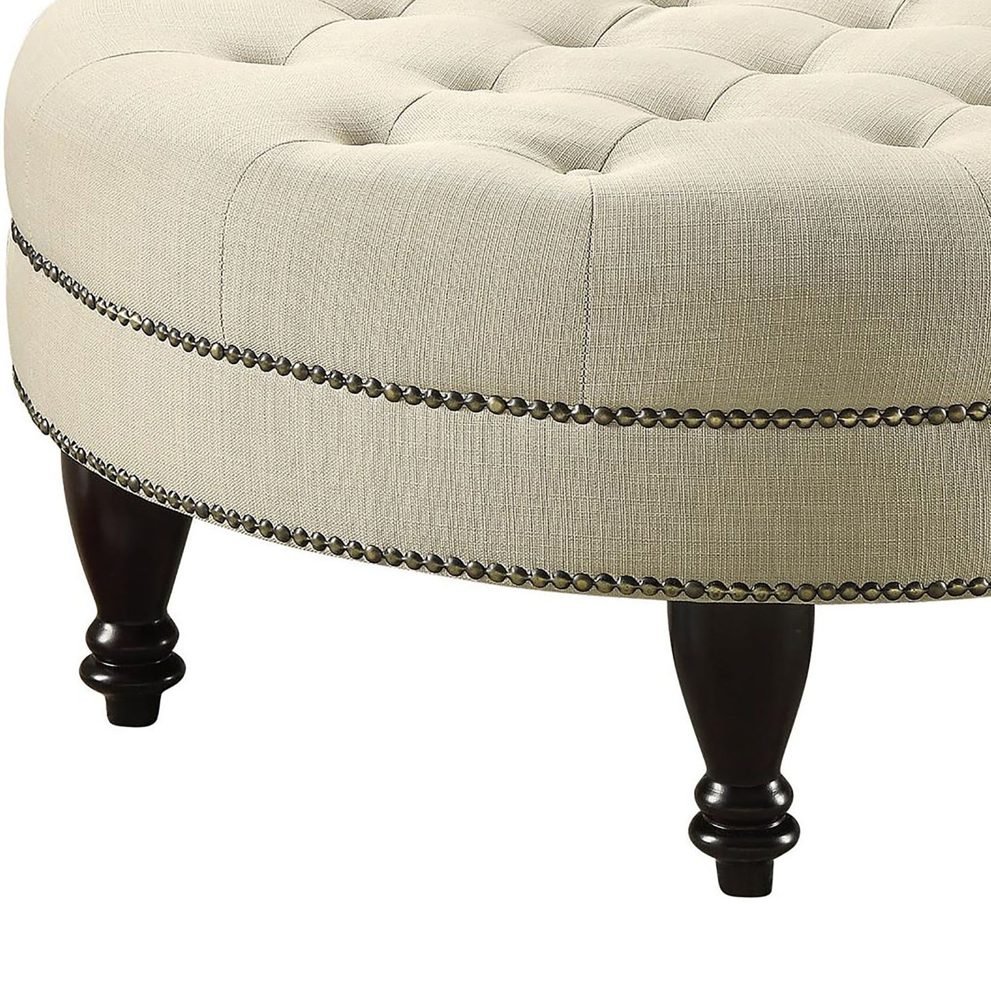 Cream linen upholstered ottoman with button tufting and antique brass nailhead trim
