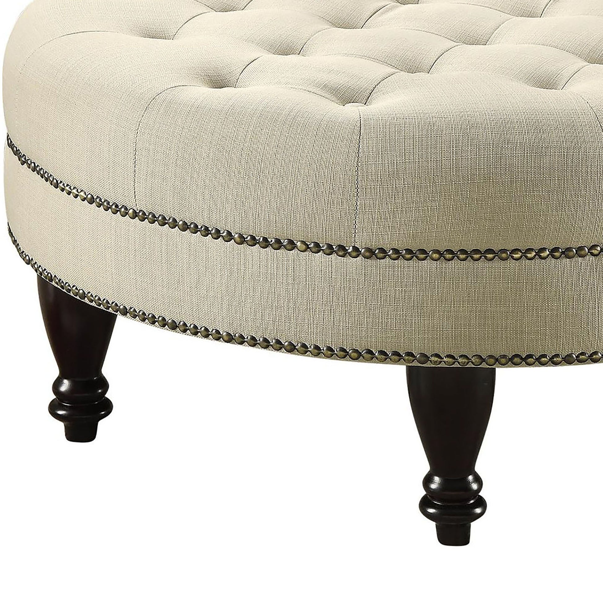 Cream linen upholstered ottoman with button tufting and antique brass nailhead trim
