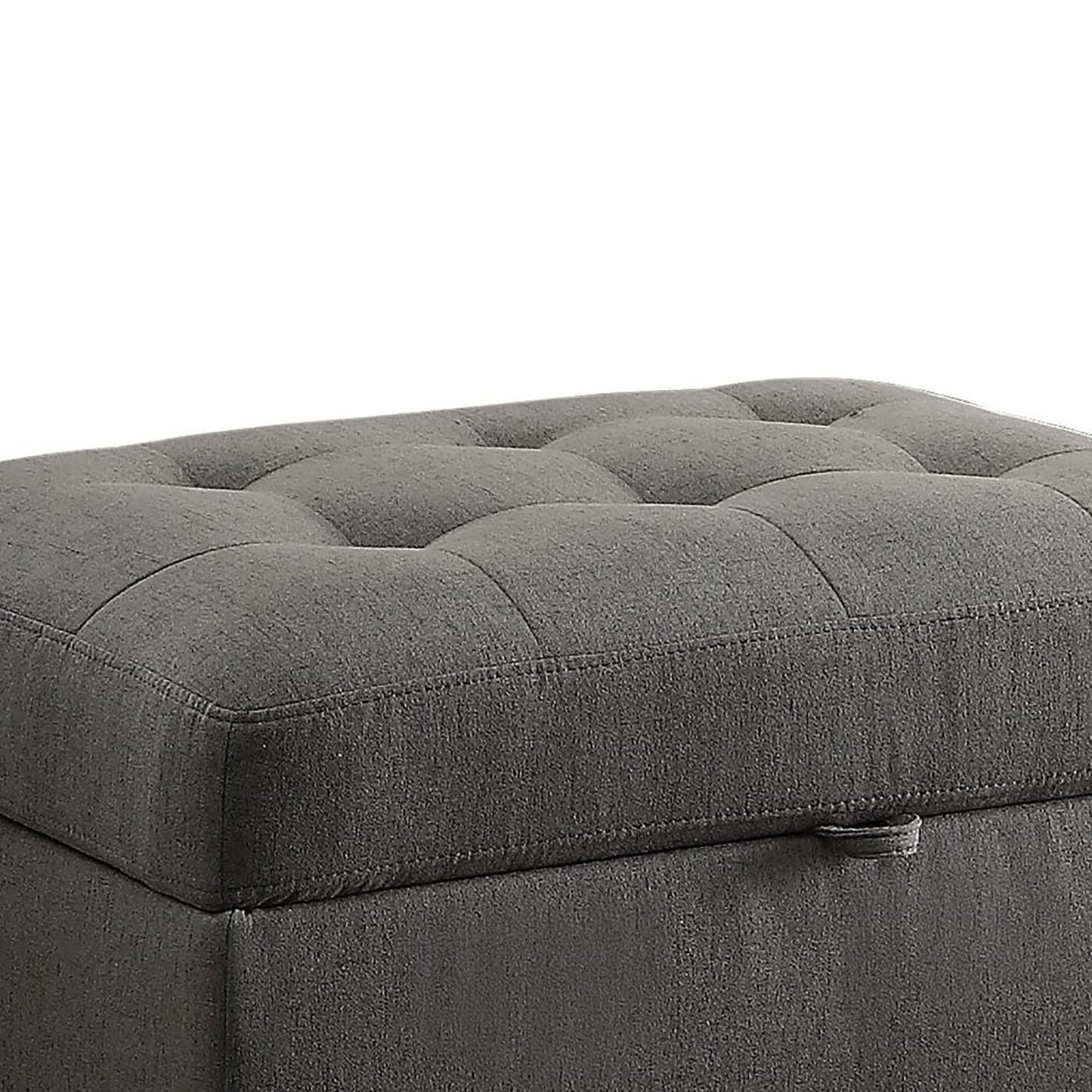 Dark gray fabric storage ottoman with tufted top and side pull tab for easy opening