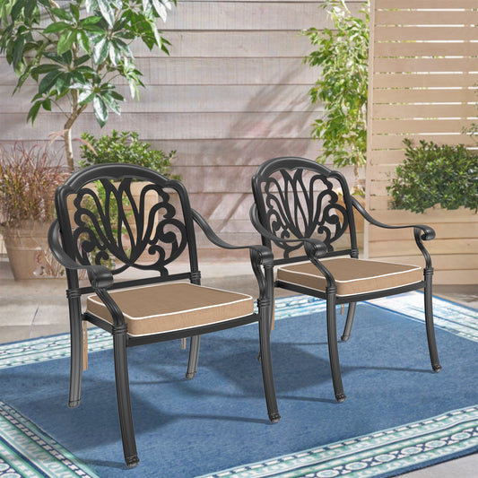 Two black ornate patio chairs with tan cushions on a blue rug