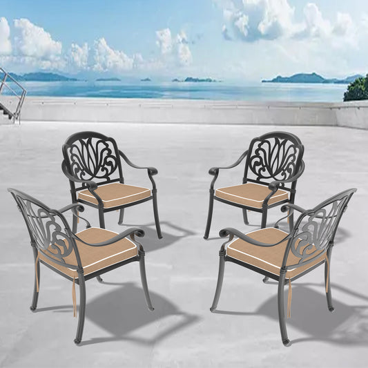 Four black ornate metal patio chairs with tan cushions and white piping arranged outdoors