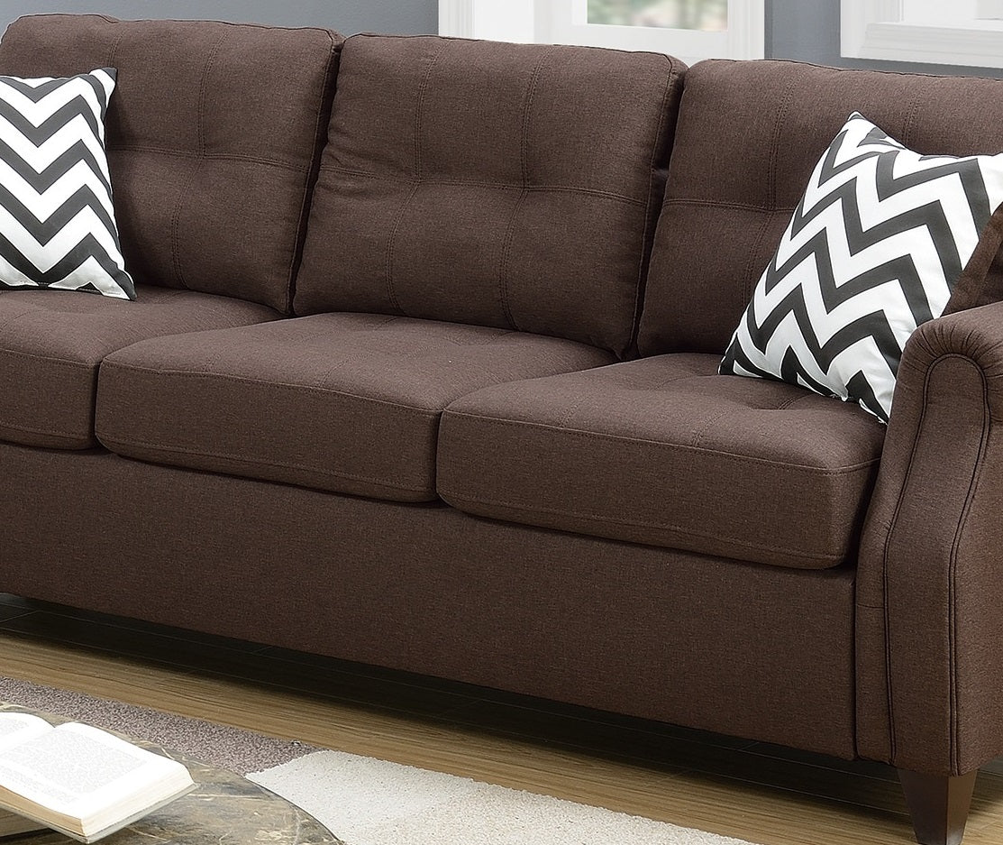 Brown upholstered sofa with tufted back cushions and chevron pillows