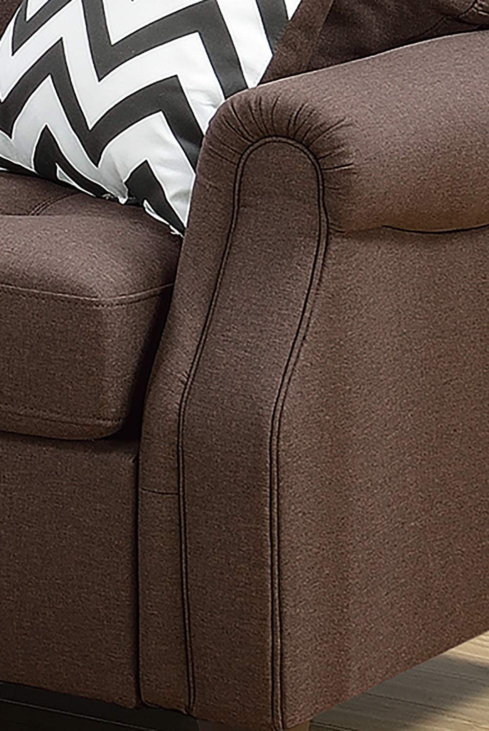 Closeup of a plush brown fabric armchair armrest with decorative stitching