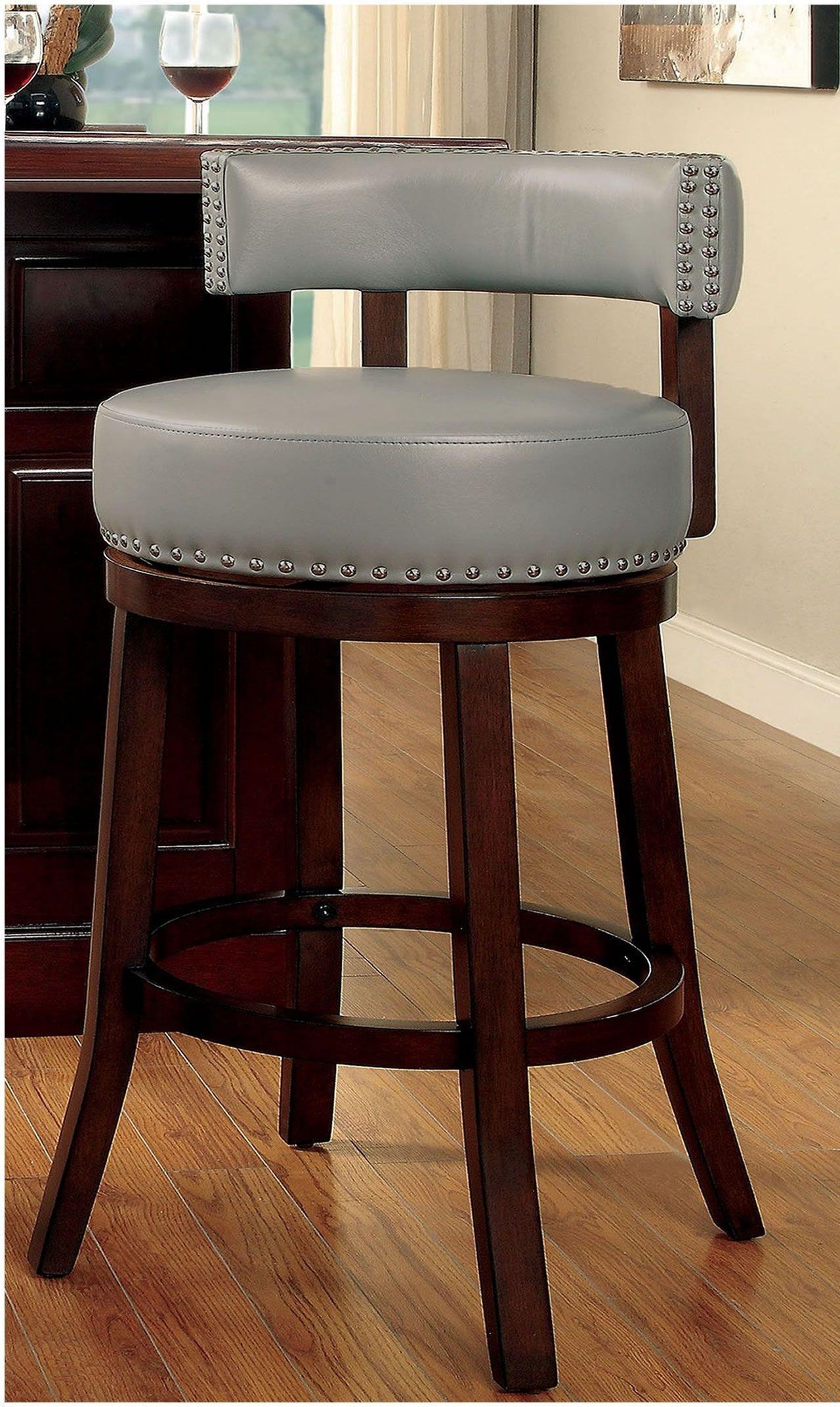 Grey faux leather bar stool with wooden legs and silver nailhead trim perfect for a kitchen island