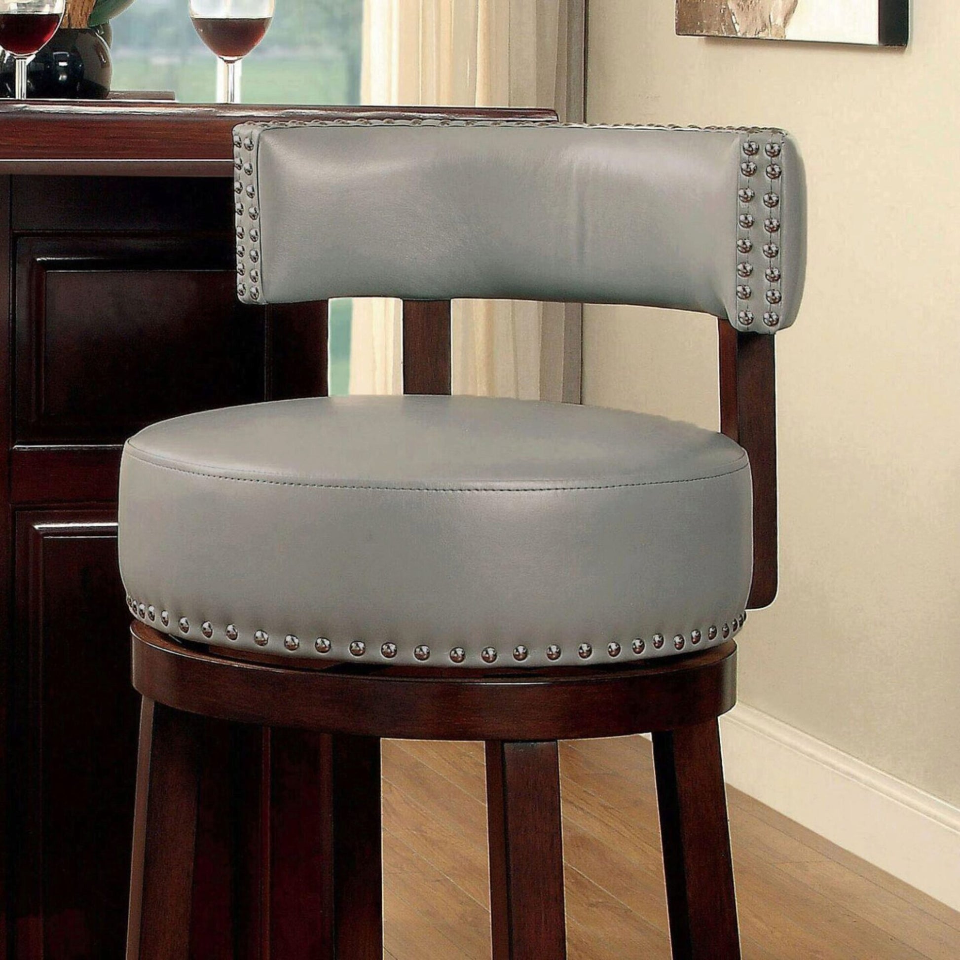 Tufted grey leather bar stool with nailhead trim and mahogany finish