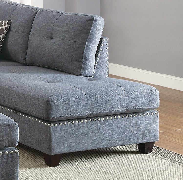 Grey fabric sectional sofa with silver nailhead trim and tufted cushions