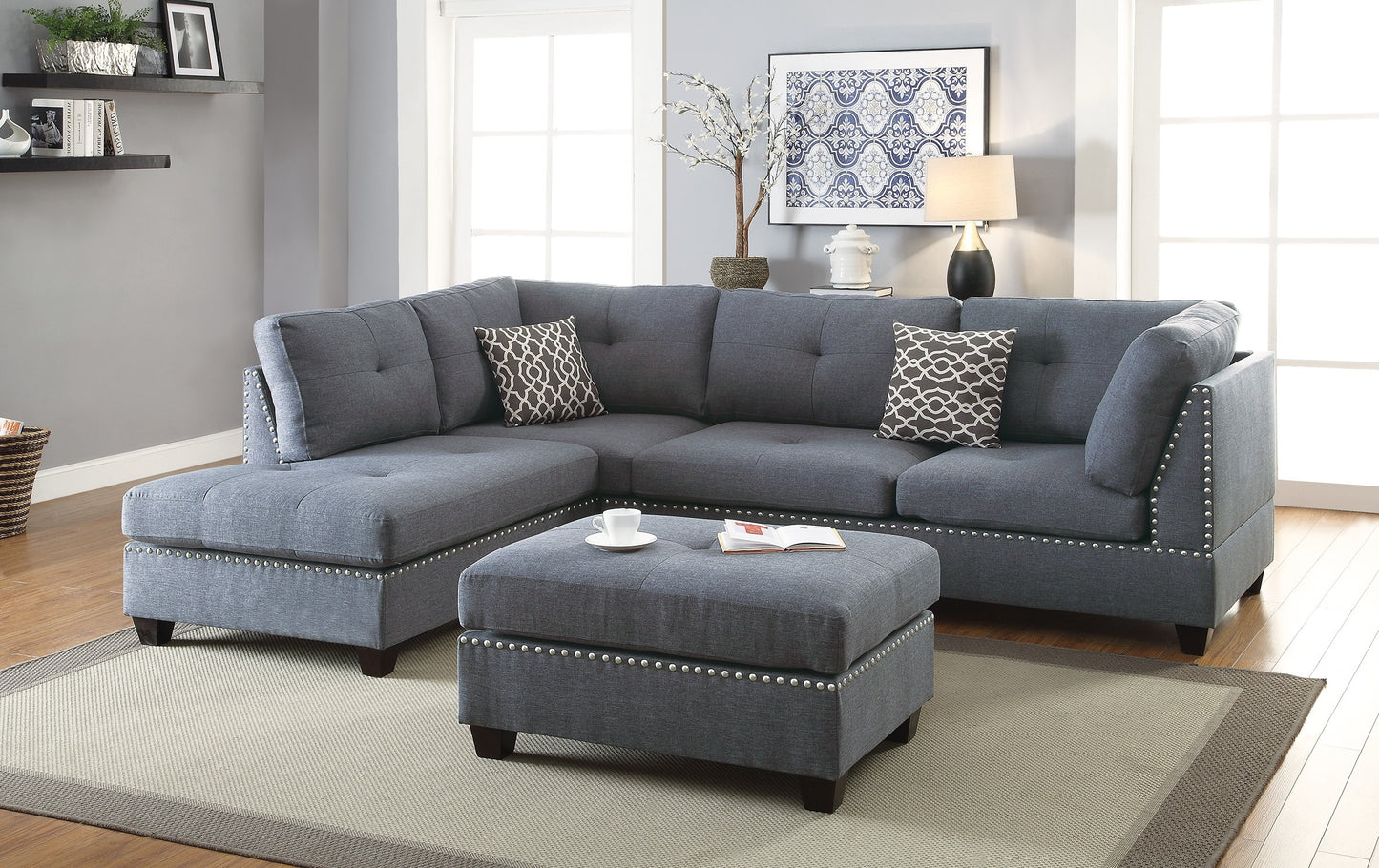 Tufted charcoal gray fabric sectional sofa with silver nailhead trim and decorative pillows